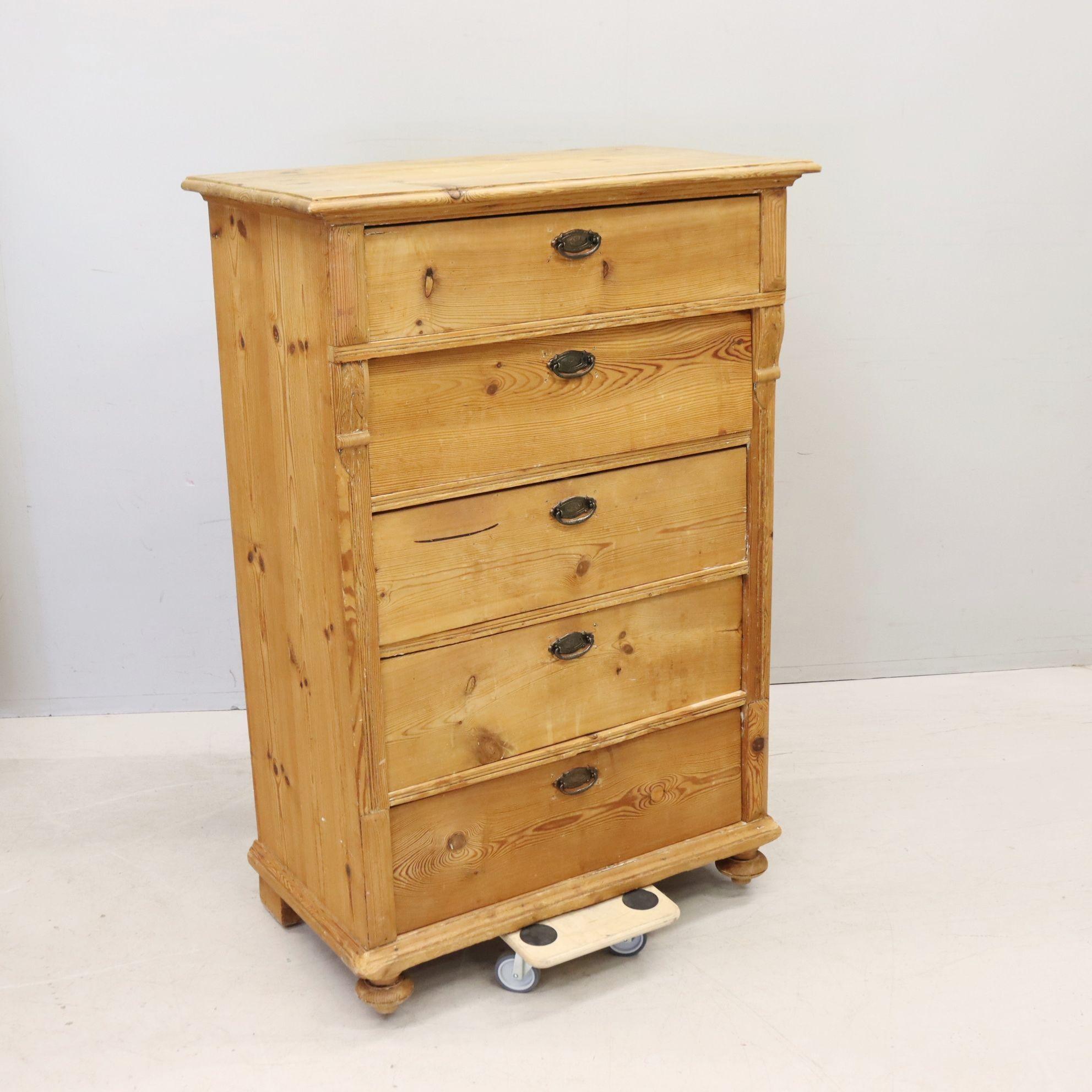 19th century Swedish unfinished pine tall chest of drawers. This antique dresser from the 1800s was crafted from rich Scandinavian pine and features five generous drawers and elegant bun feet along with its original brass drawer pulls. Beautiful