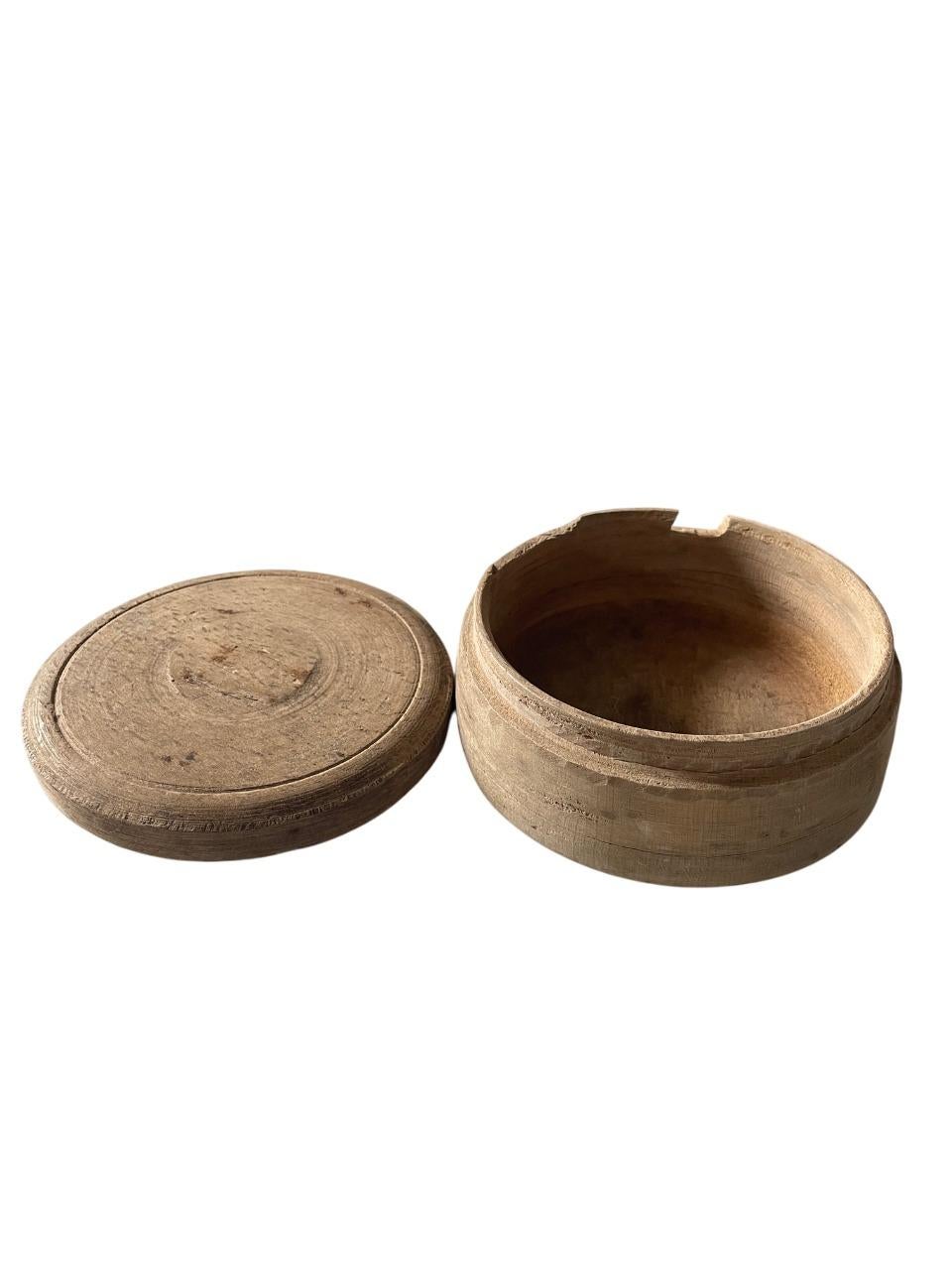 A soulful 19th-century lidded box handcrafted in Sweden from solid oak, showcasing the quiet beauty of the wabi-sabi aesthetic. This simple, round form reveals a deep, weathered patina, bearing the marks of time and use. Its minimal, rustic design