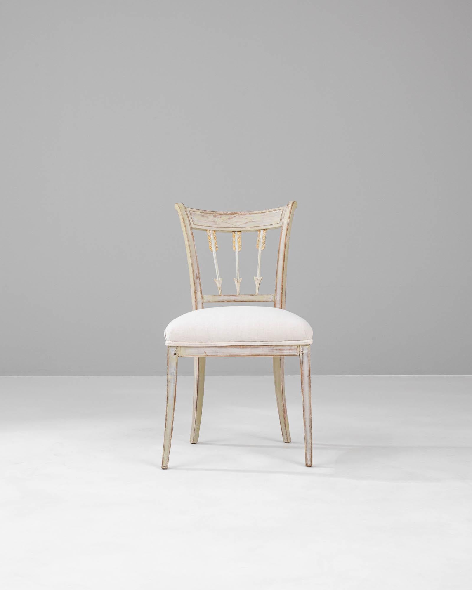 Adorn your living space with a touch of Swedish elegance with this 19th Century Wood White Patinated Chair. Its graceful curves and classic spindles are accentuated by a time-softened white patina, creating an aura of romantic nostalgia. The chair's