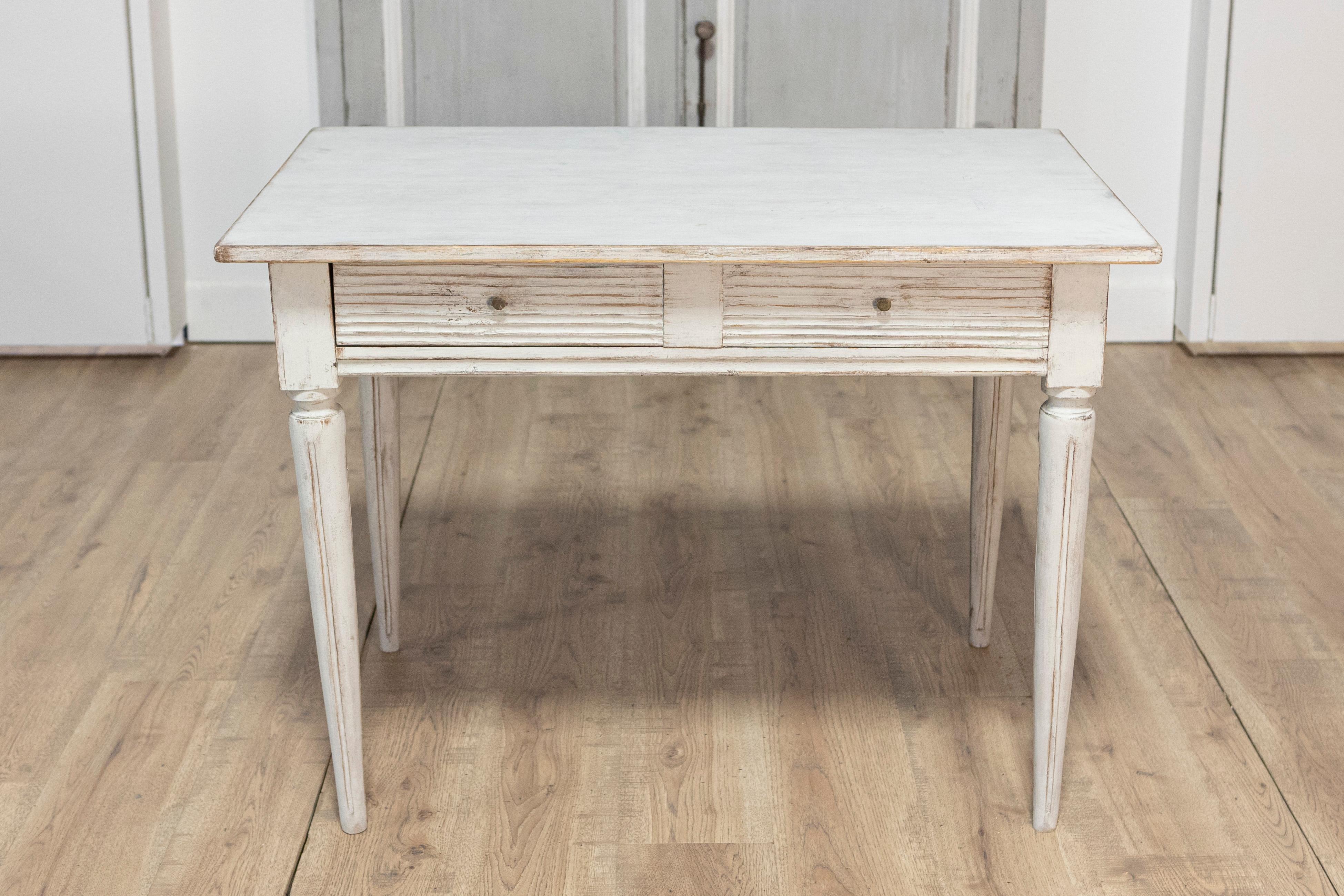 Questo elegante scrittoio svedese del XIX secolo esemplifica il fascino senza tempo del design gustaviano, combinando funzionalità e bellezza discreta. Realizzata in legno di pino massiccio, la scrivania presenta un piano rettangolare sostenuto da