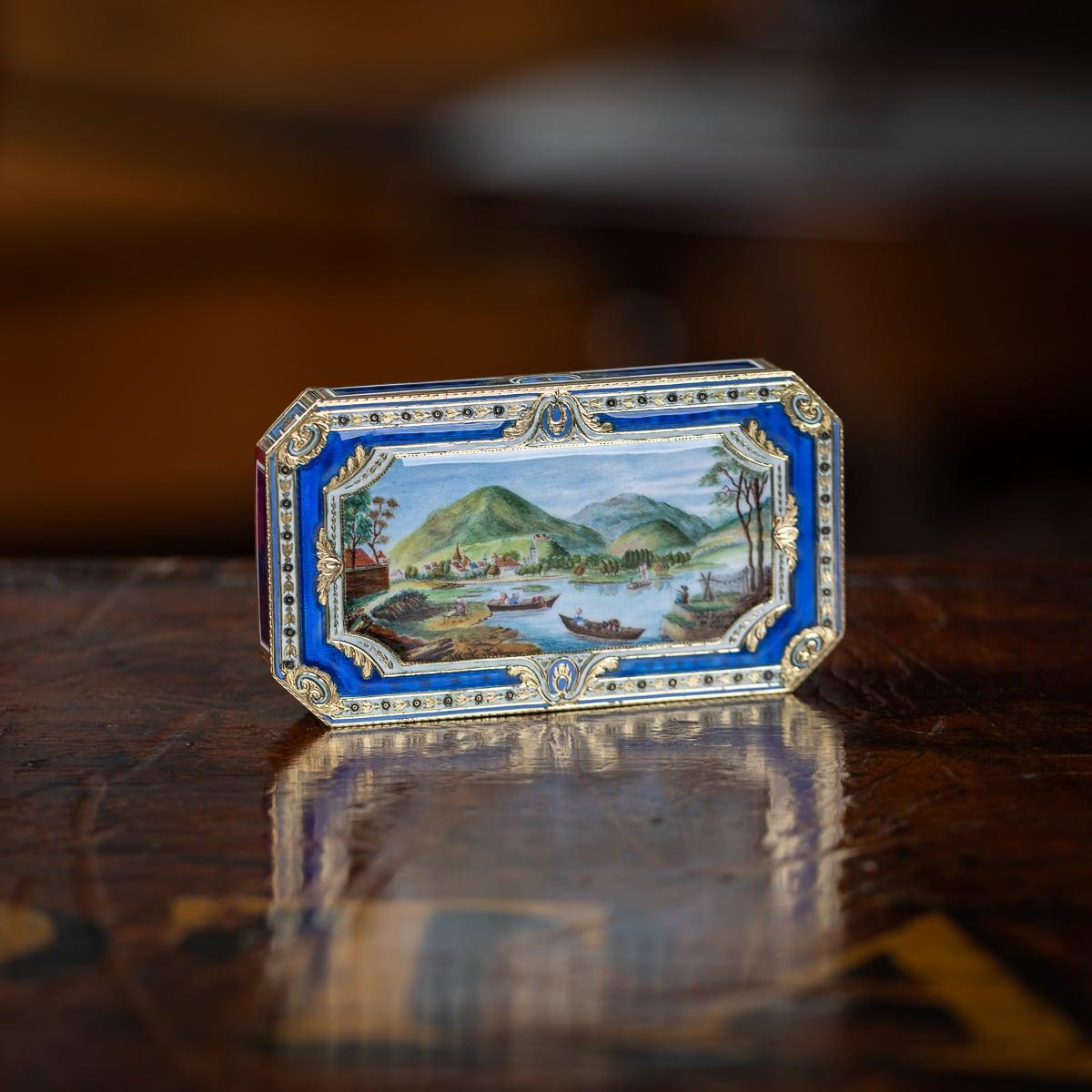 Antique early-19th Century Swiss 18k gold & enamel snuff box, of rectangular form, with cut corners, the hinged lid is adorned with a charming scene depicting a picturesque harbor scene with a village and mountains in the background, signed Ville de