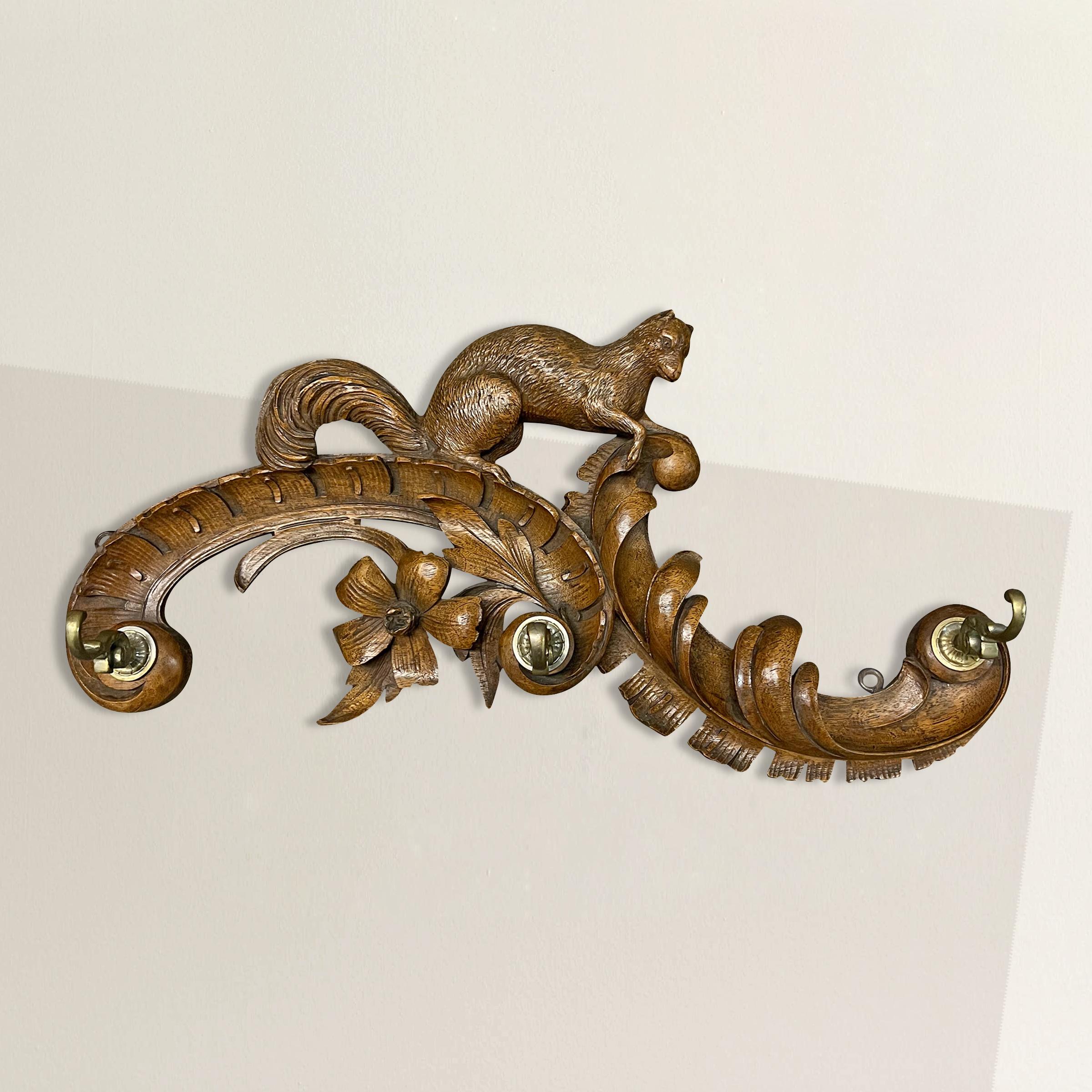 This exquisite 19th-century Swiss Alpine wood carving is a true testament to the artistry and craftsmanship of the region. Carved from rich walnut, it features an adorable squirrel playfully ascending two Rococo-style acanthus leaf volutes,