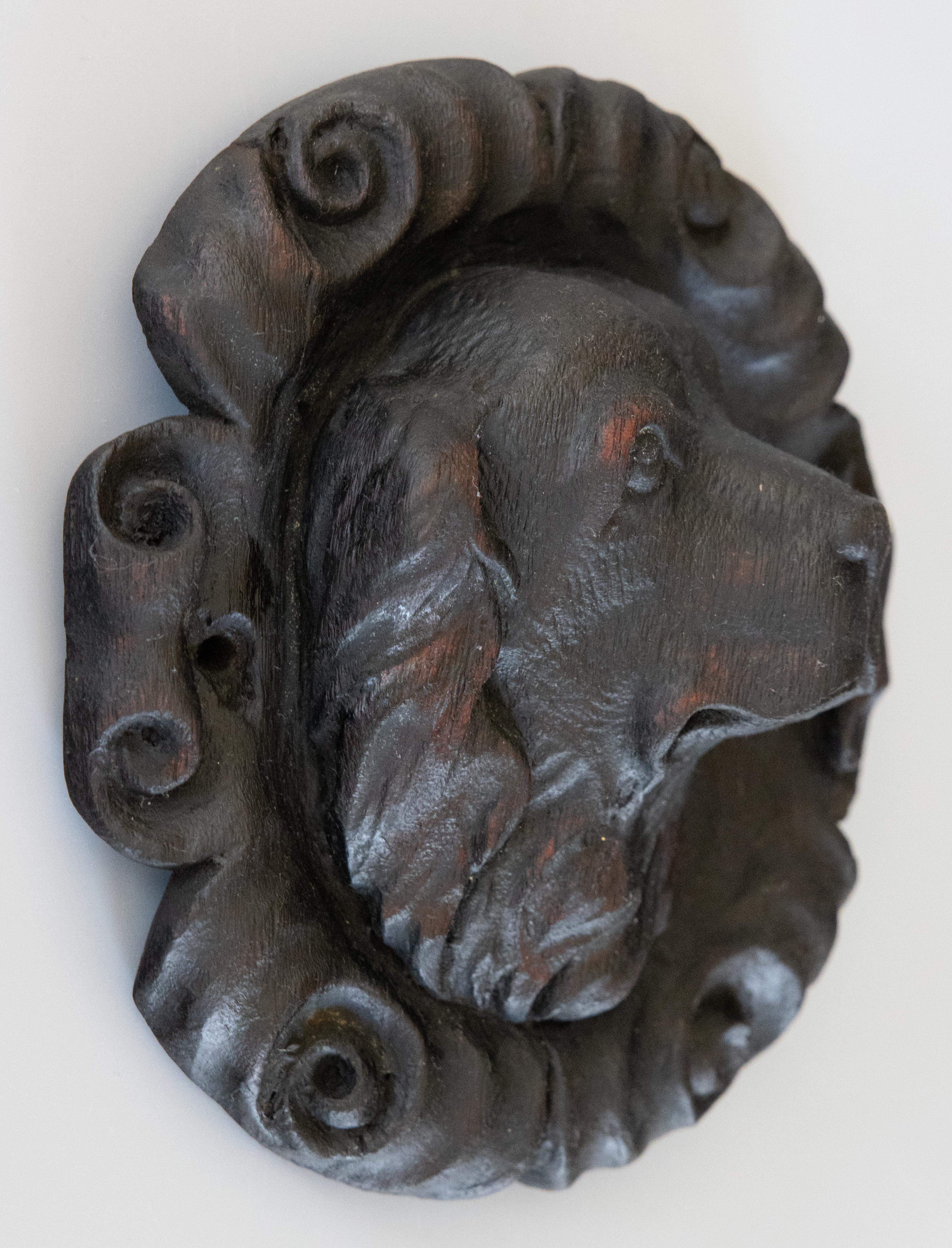 A fine antique 19th-Century black forest Swiss hand carved sporting dog head sculpture plaque. This handsome plaque is finely carved with exceptional details and expression in the spaniel's face which is surrounded by scrollwork. It's perfect for