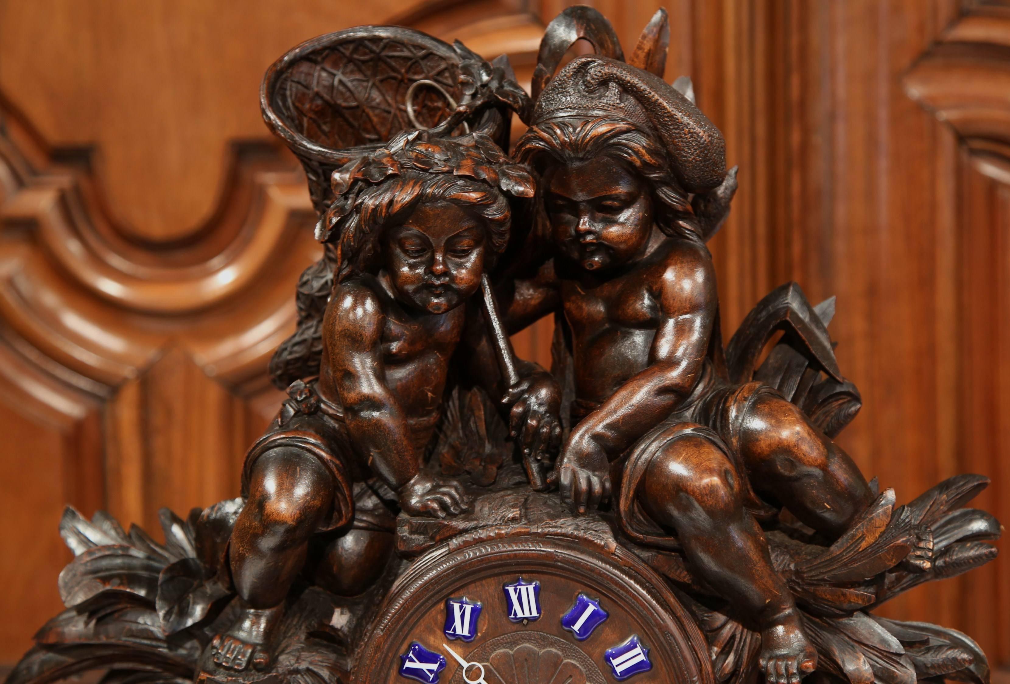 Decorate your buffet or mantel with this monumental antique fruitwood clock. Crafted in Switzerland, circa 1860, the masterpiece time keeper features two hand carved seated cherubs holding a grape basket with a duck, frog and reed decor underneath.