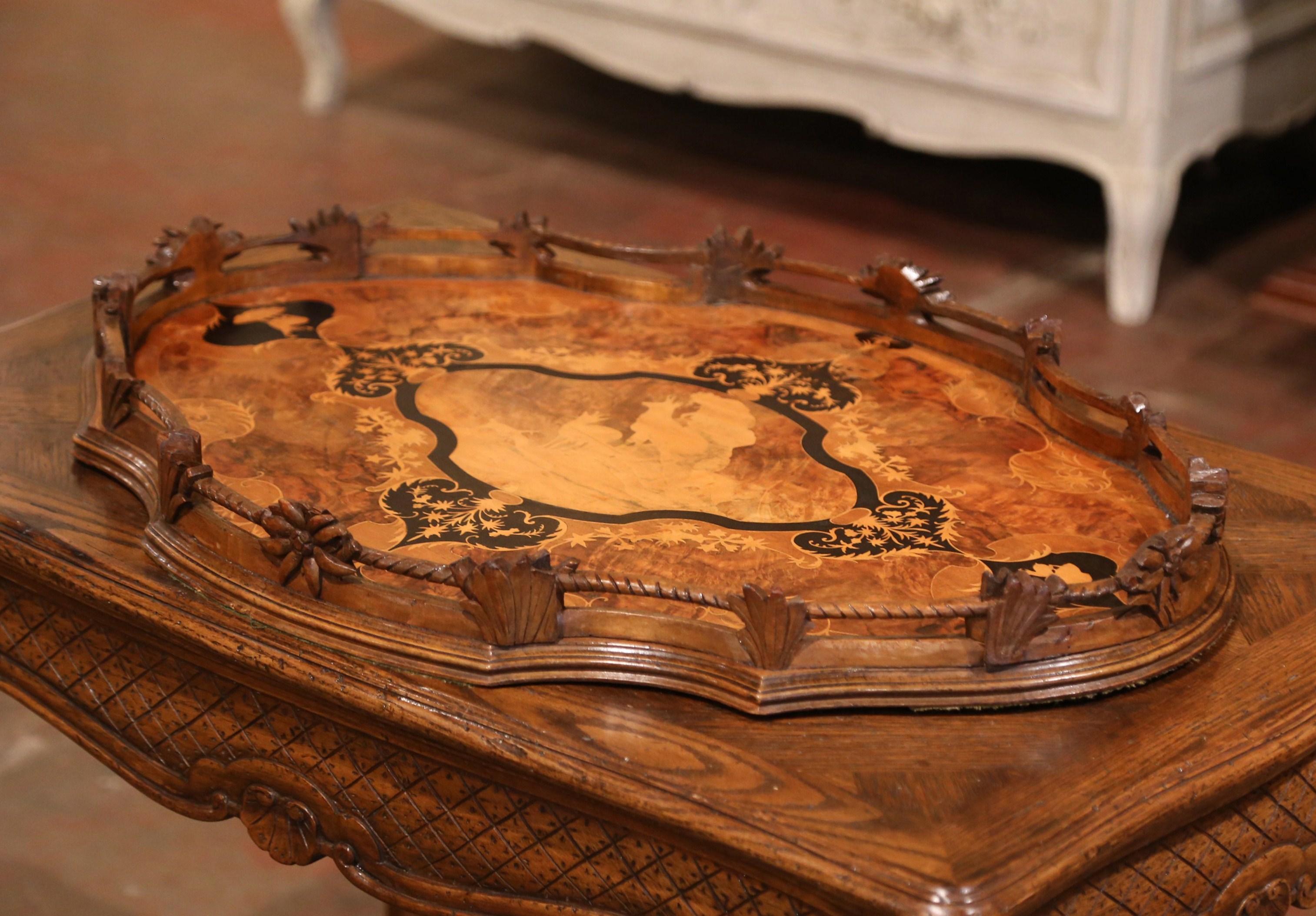 Crafted in Switzerland, circa 1870, and oval in shape, the large antique tray features a shaped top with a carved gallery decorated with floral and leaf motifs. The center medallion with deer standing on rocky ground has beautiful, illustrative