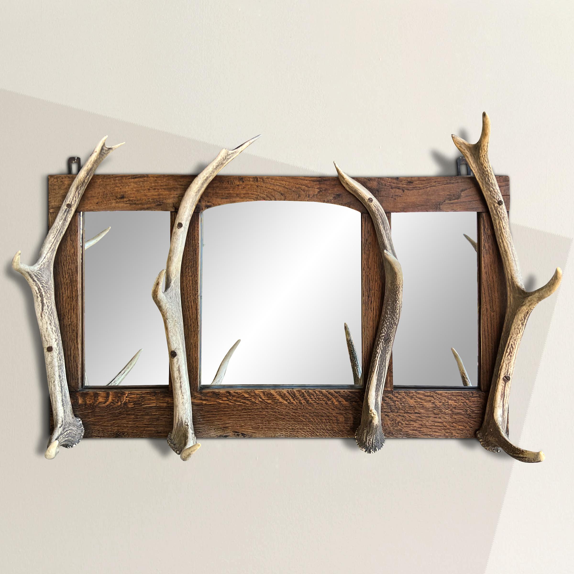 This late 19th-century Swiss Black Forest stag antler coat and hat rack is a testament to the rich tradition of decorative arts originating from the enchanting Black Forest region. The Black Forest is renowned for its masterful woodcraft, and this