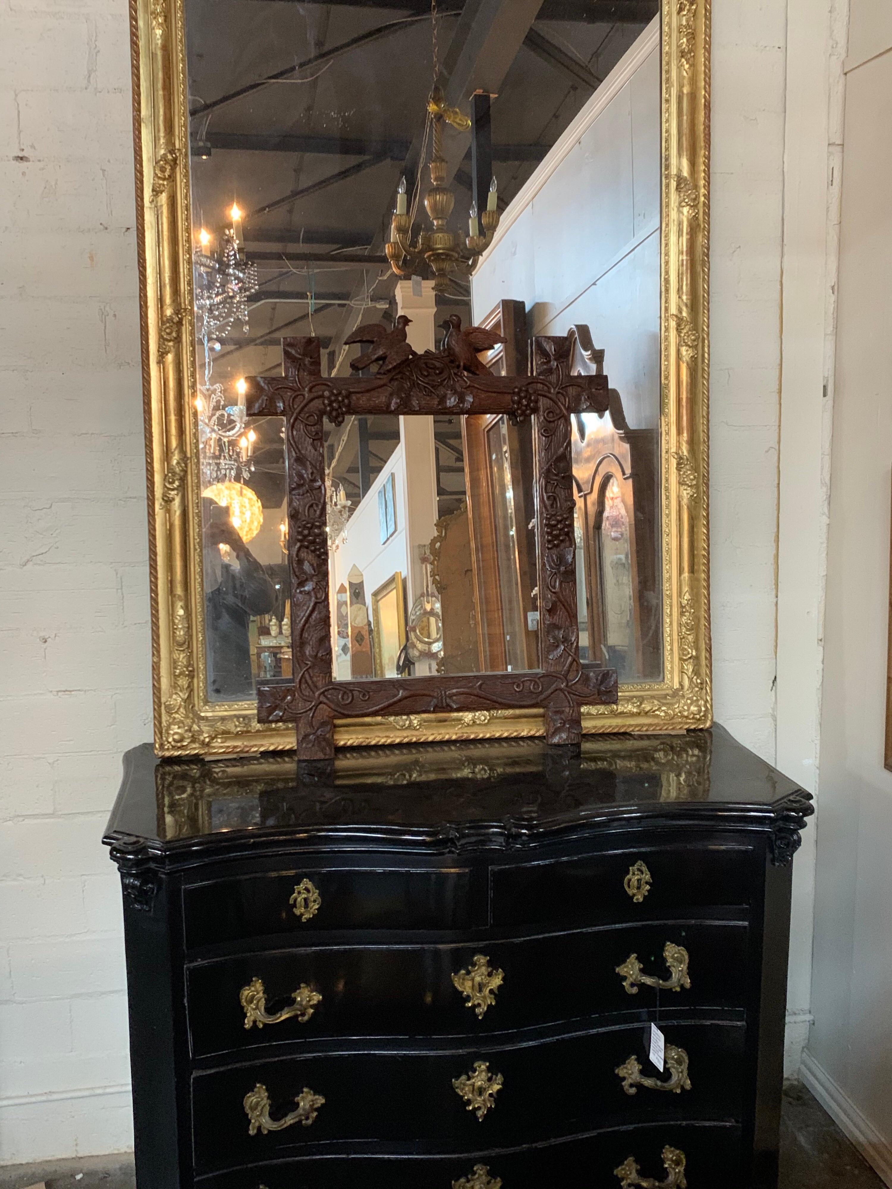 Handsome 19th century Swiss carved walnut Black Forest mirror. Lovely images of grapevines and birds. The carving on this mirror is exquisite! This would make a fine accessory in a lovely home.