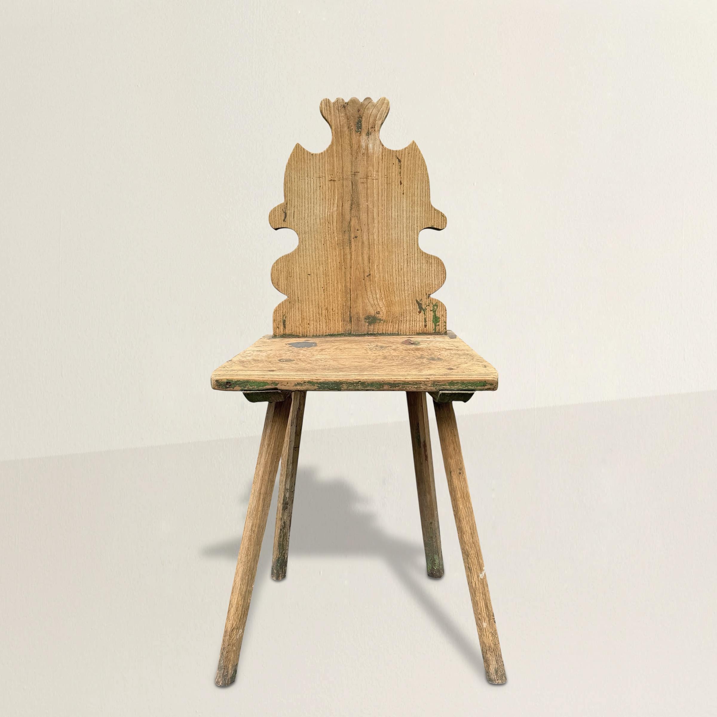 Esta silla auxiliar tirolés-suiza del siglo XIX capta el singular espíritu del diseño alpino, donde confluyen la utilidad, el folclore y un toque de capricho. Fabricada en madera de pino, la silla tiene un respaldo macizo con una estilizada silueta