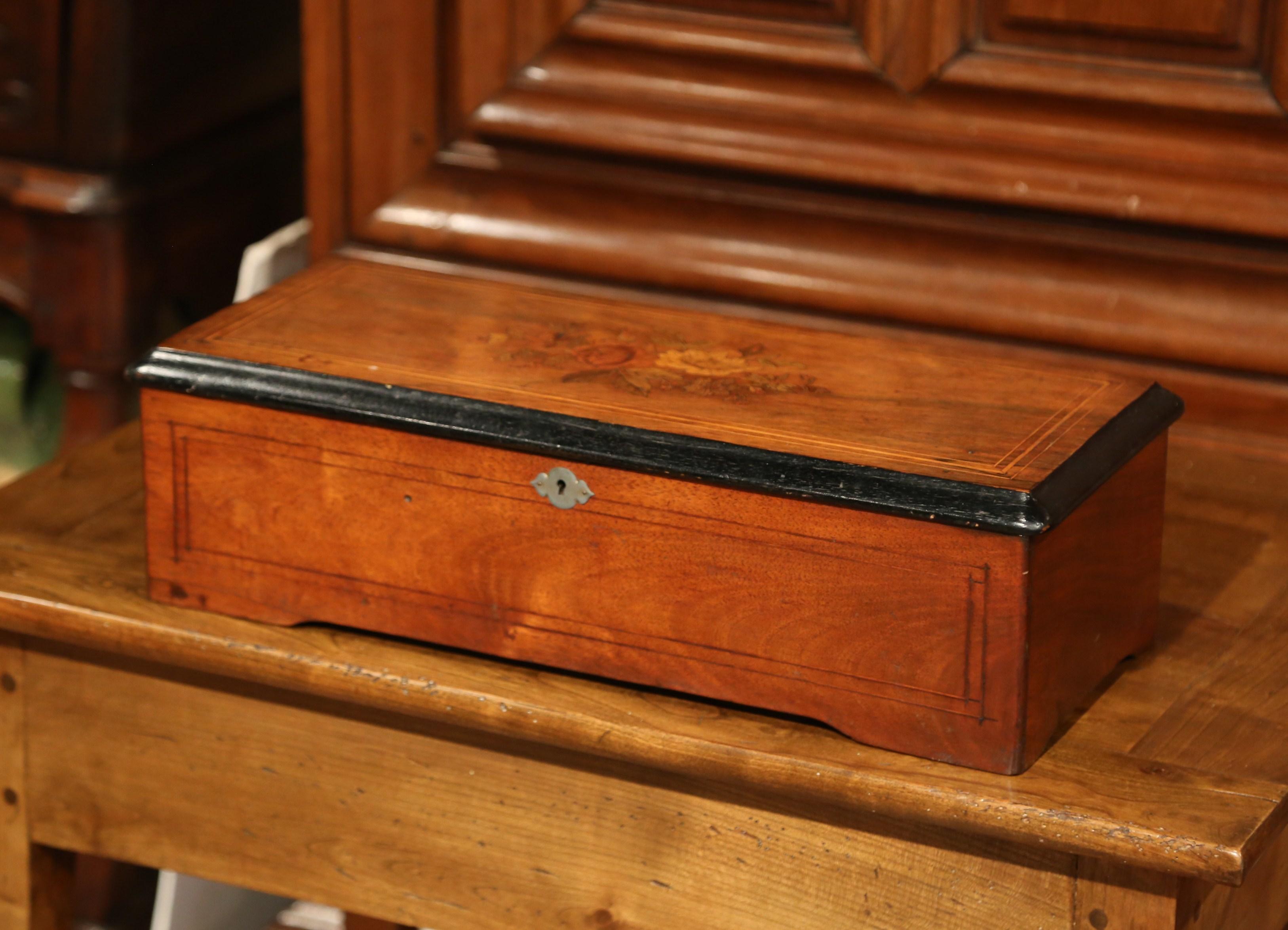 Listen to soft, cheerful music in your living room with this traditional, antique music box. Crafted in Switzerland circa 1870, and attributed to the Paillard Vaucher Fils, the locking walnut case is inlaid with tulip wood marquetry. The box is