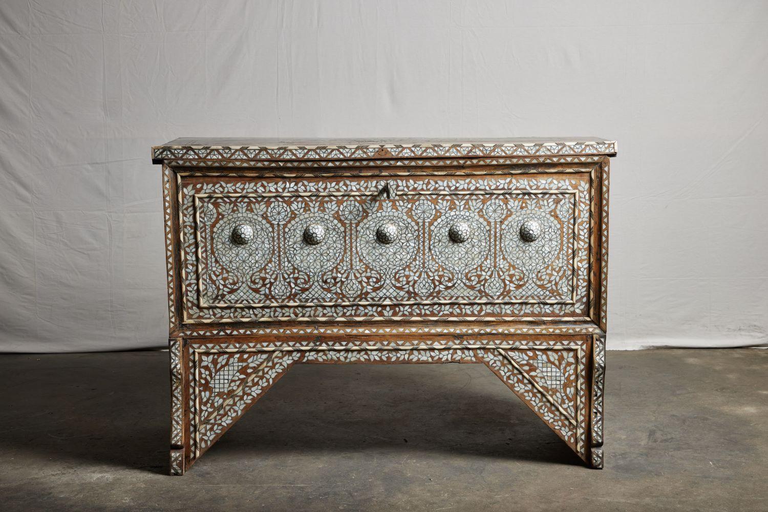 A heavily inlaid Syrian wedding chest with key. Lighter-toned blonde wood on a lovely stand. Syrian dowry wedding chest showcasing very fine intricate mother-of-pearl inlay.