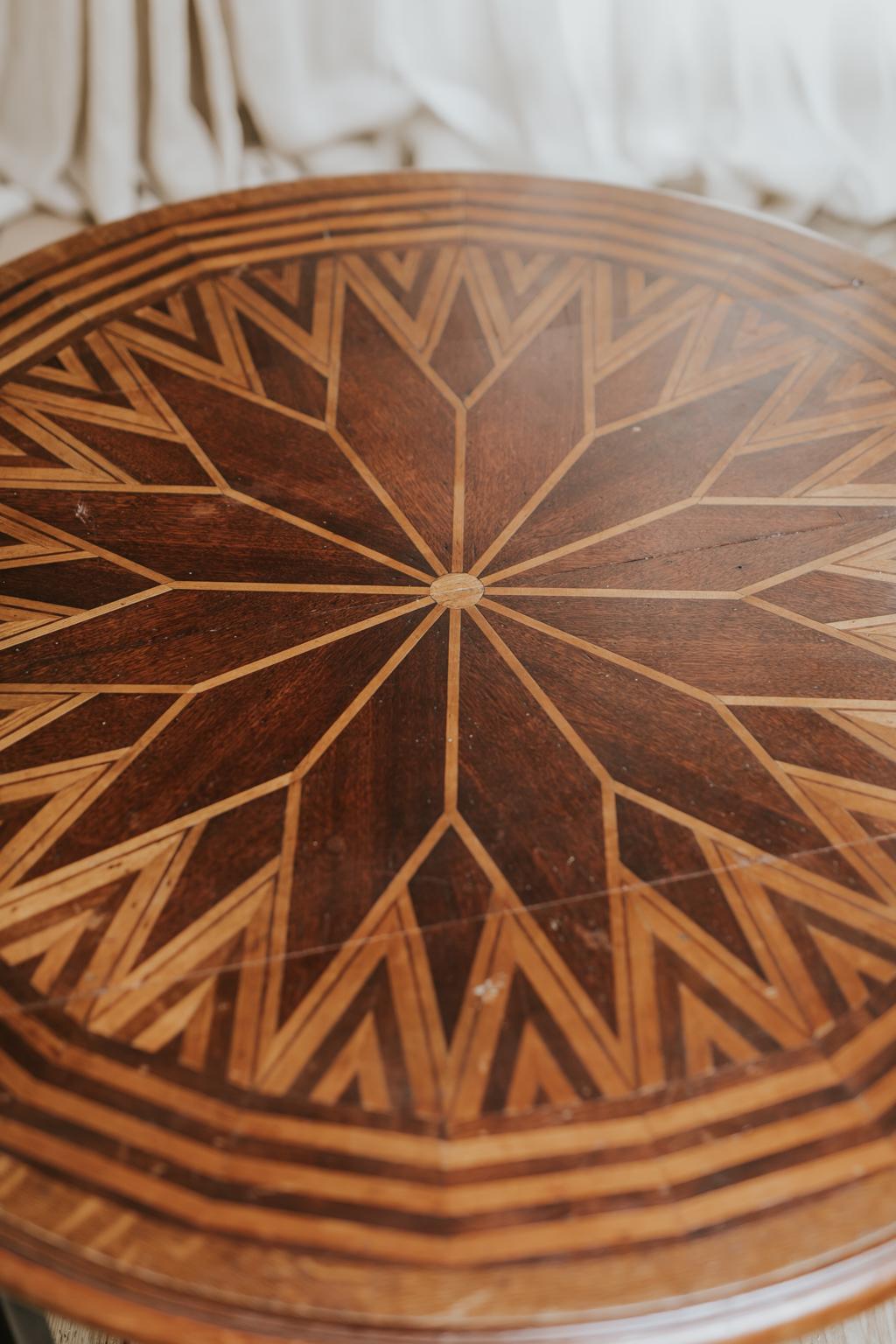 Creation of a coffee table, top is a 19th century star inlay tabletop,
mounted on a contemporary iron base.