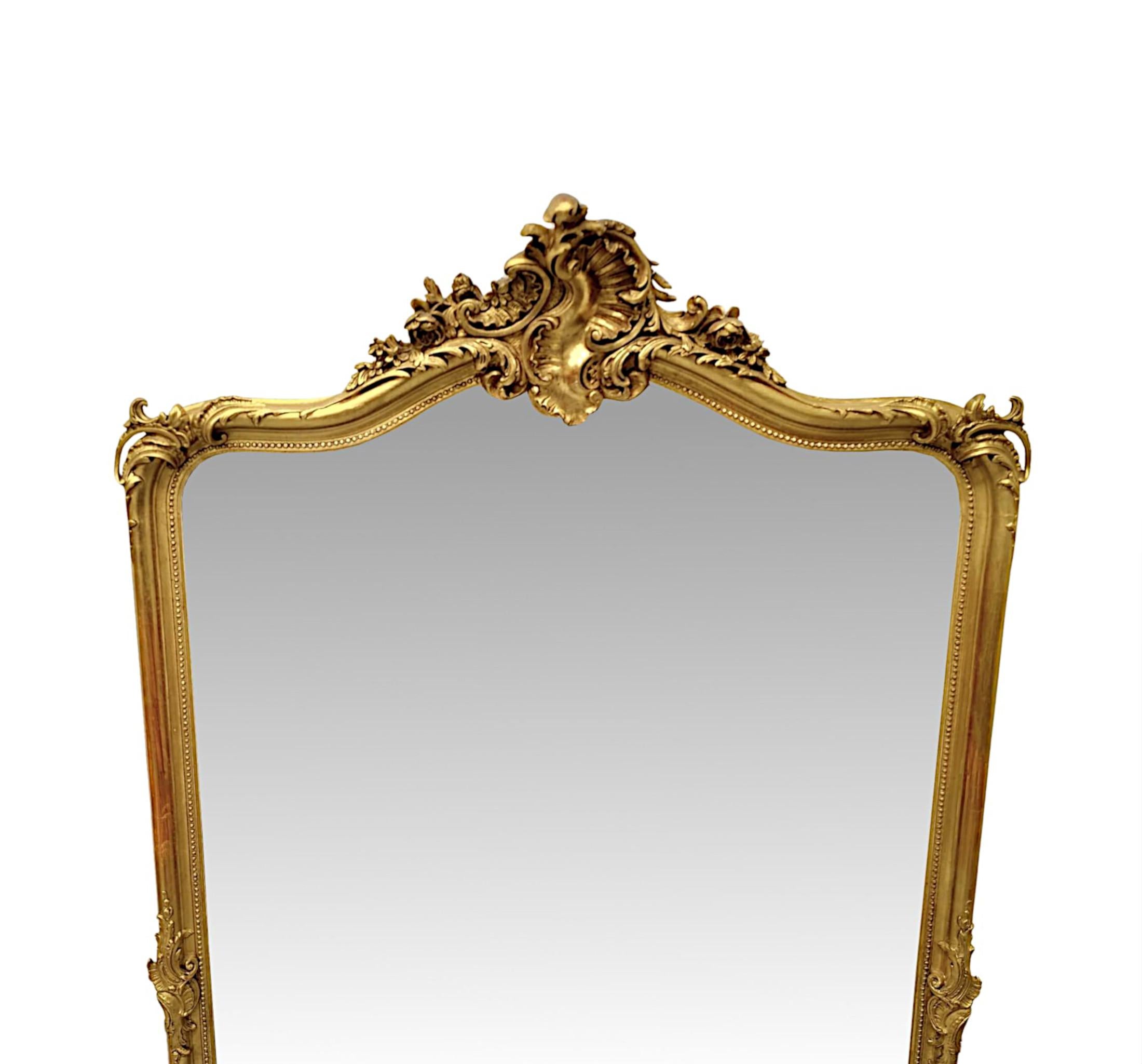 Un raffinato specchio da sala in legno dorato del XIX secolo di qualità eccezionale e di proporzioni alte e strette.  La lastra di vetro a specchio sagomato e curvo è incastonata in una splendida cornice in legno dorato intagliato a mano, scanalato