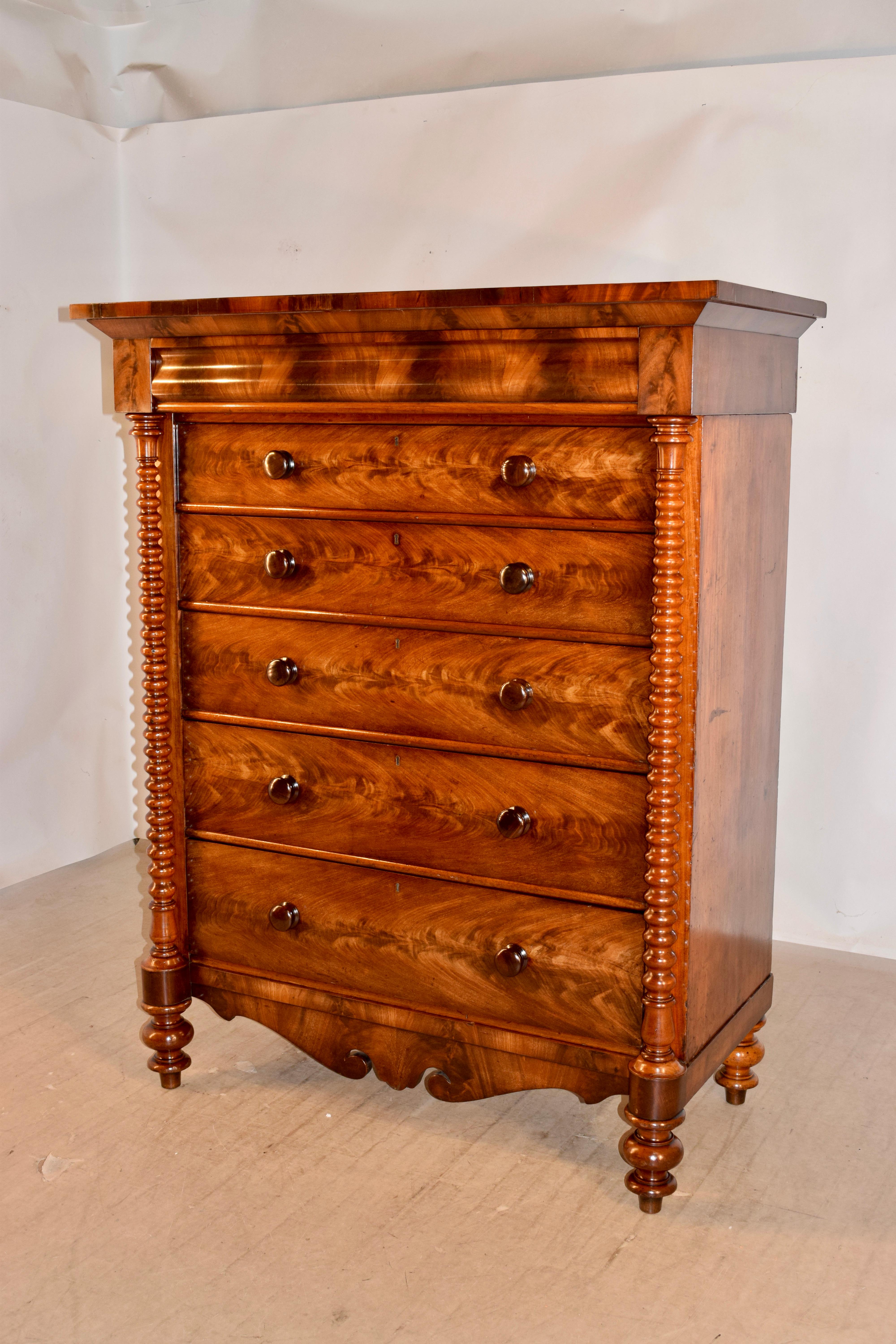 19th century tall flame mahogany chest from Scotland. The graining of the wood is breath-taking, and is a showpiece all in itself. The case has simple sides, and in the front, there is a molded hidden drawer at the top, over five drawers, all with
