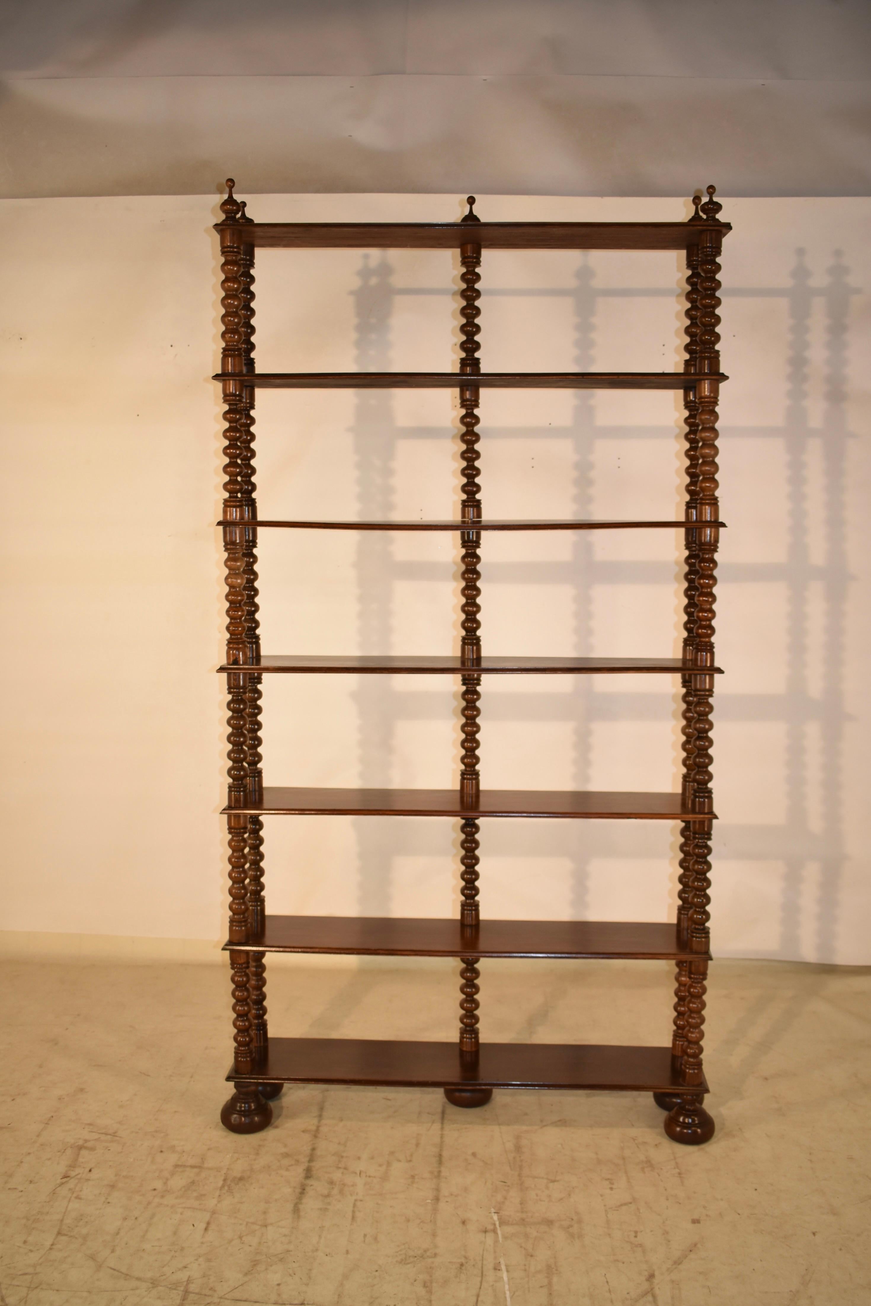 19th Century tall standing shelf from France, made from walnut. It has wonderfully hand turned finials at the top of the piece, over six shelves, all separated by hand turned shelf supports in a bobbin pattern. The piece is supported on lovely hand