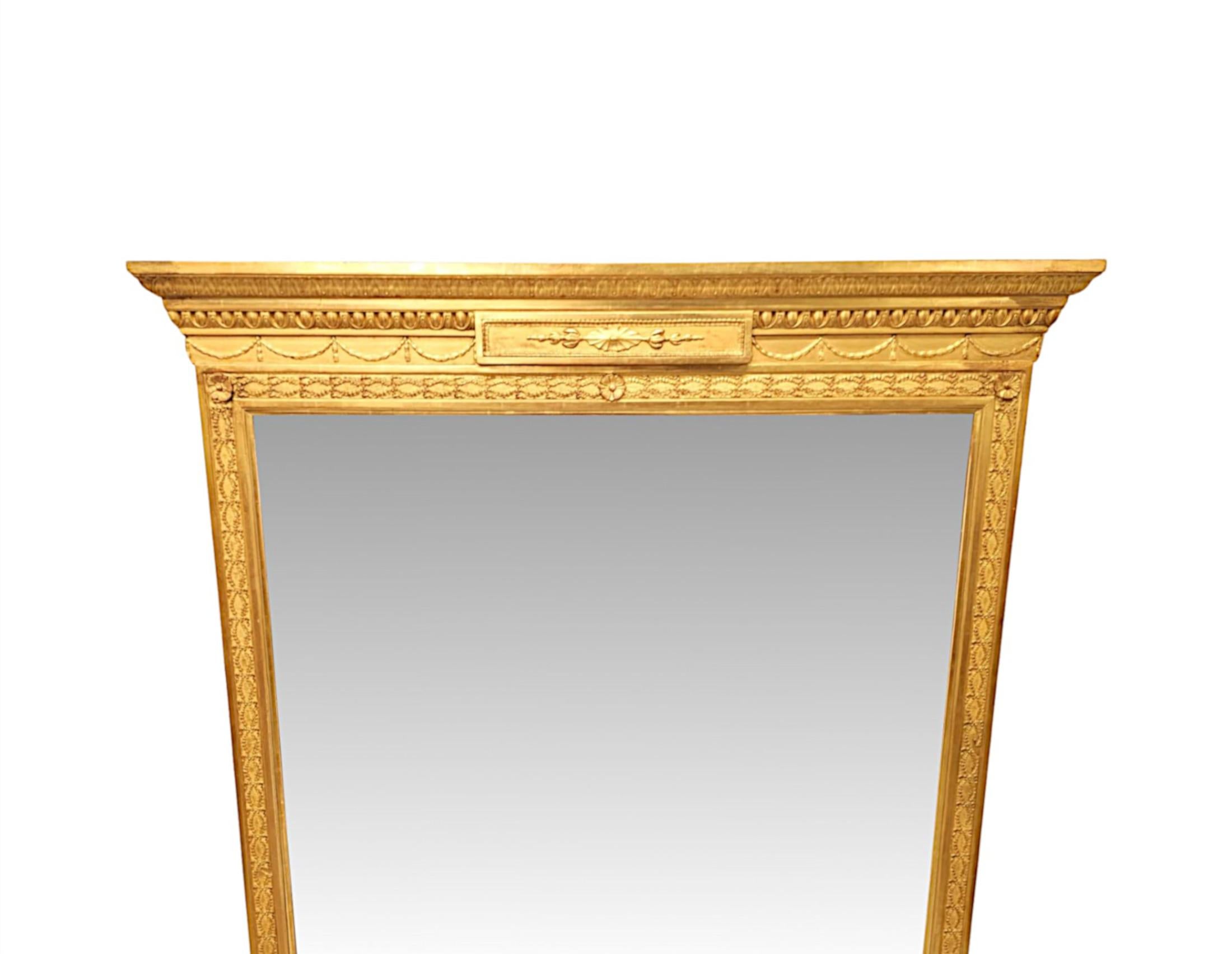Un raffinato specchio da sala in legno dorato del XIX secolo, nel disegno di Adam Hall, di proporzioni elevate e di qualità eccezionale.  La splendida cornice in legno dorato intagliato a mano, modellato e scanalato, con splendidi motivi