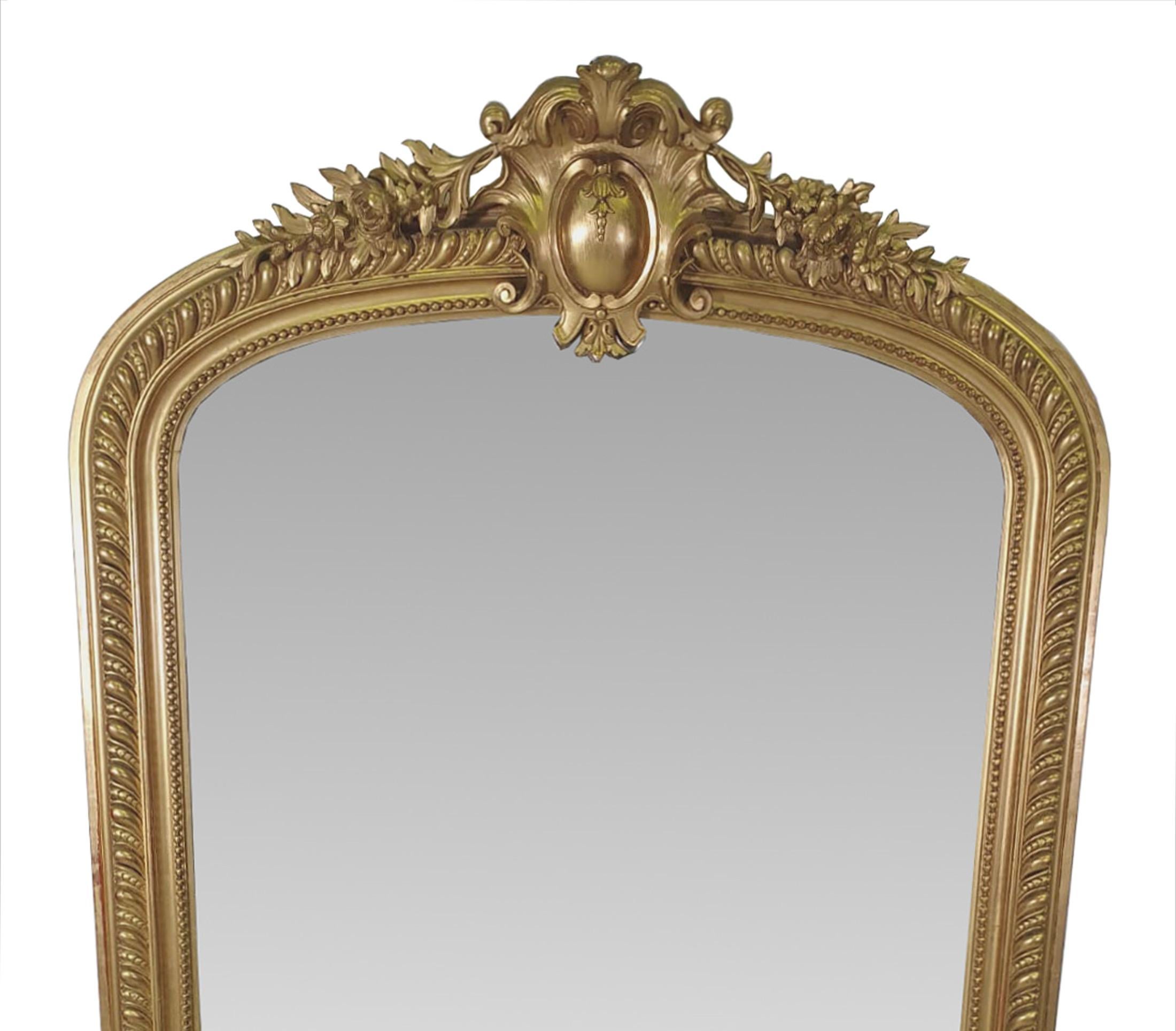 A beautiful 19th Century tall and Narrow giltwood overmantel mirror,  The hand carved gilt wood frame with scrolling foliate, beading and gadroon detail, surmounted with intricately carved crest with flower head, c-scroll and trailing foliate and