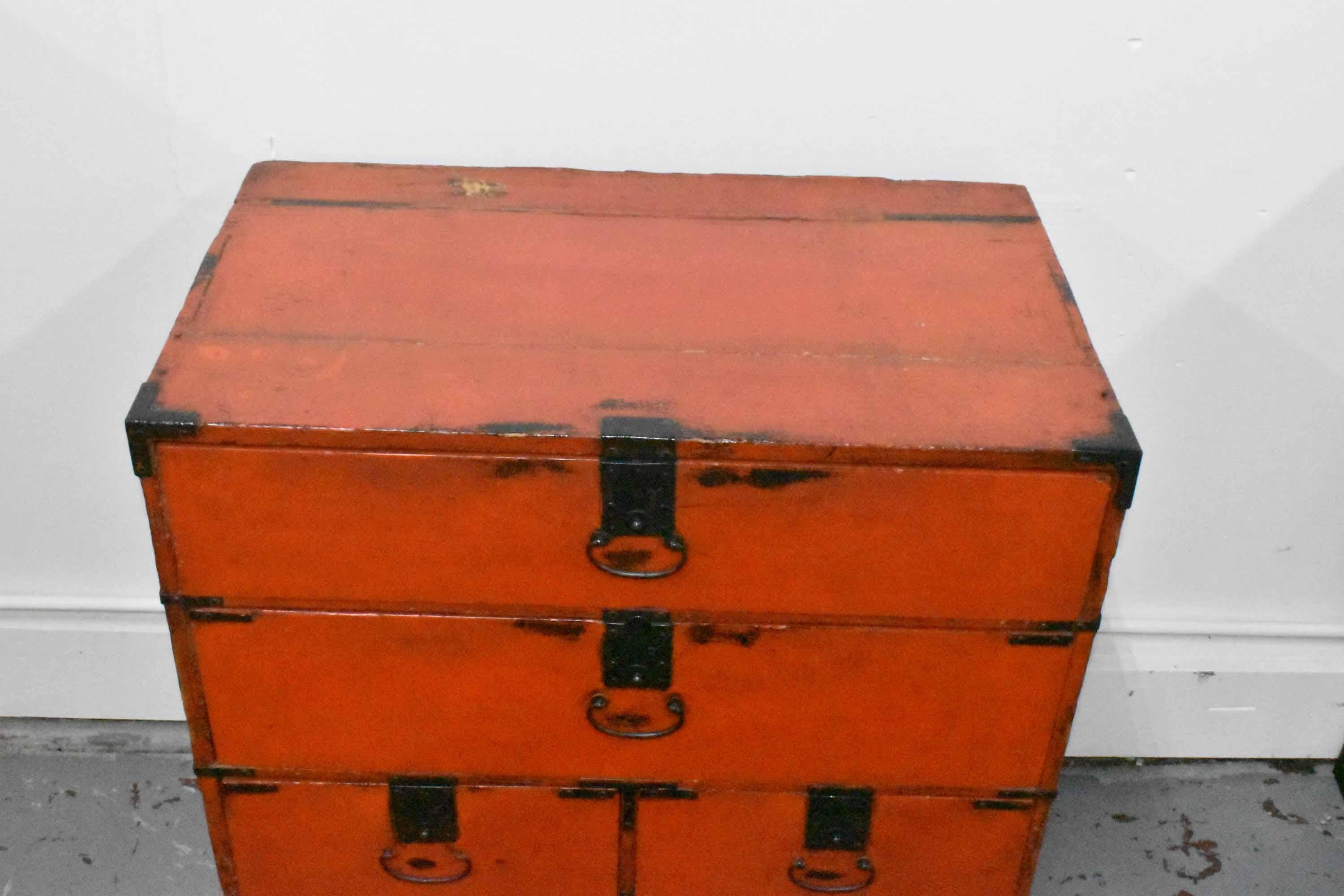 A mid-19th century Asian Tansu chest in burnt-orange lacquer, with iron handles and locks, and seven small drawers. Possibly Japanese or Korean. Nice small size, good for side stand or end table.