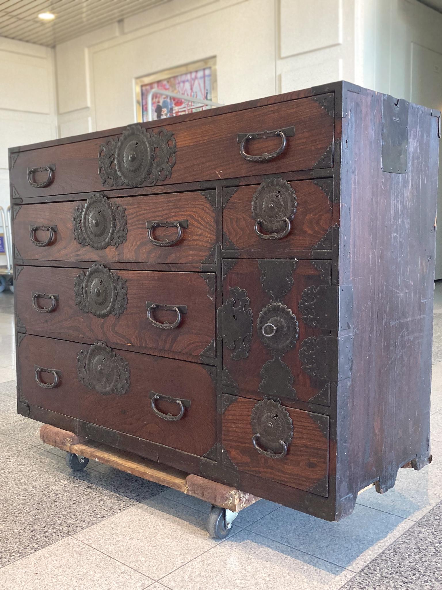19th century tansu with 6 drawers and a cabinet that opens to 3 small compartments. The intricate hardware is cast iron. The pinewood a has rich red-brown finish. We love the overall organic wear to the wood which really gives the chest its warmth