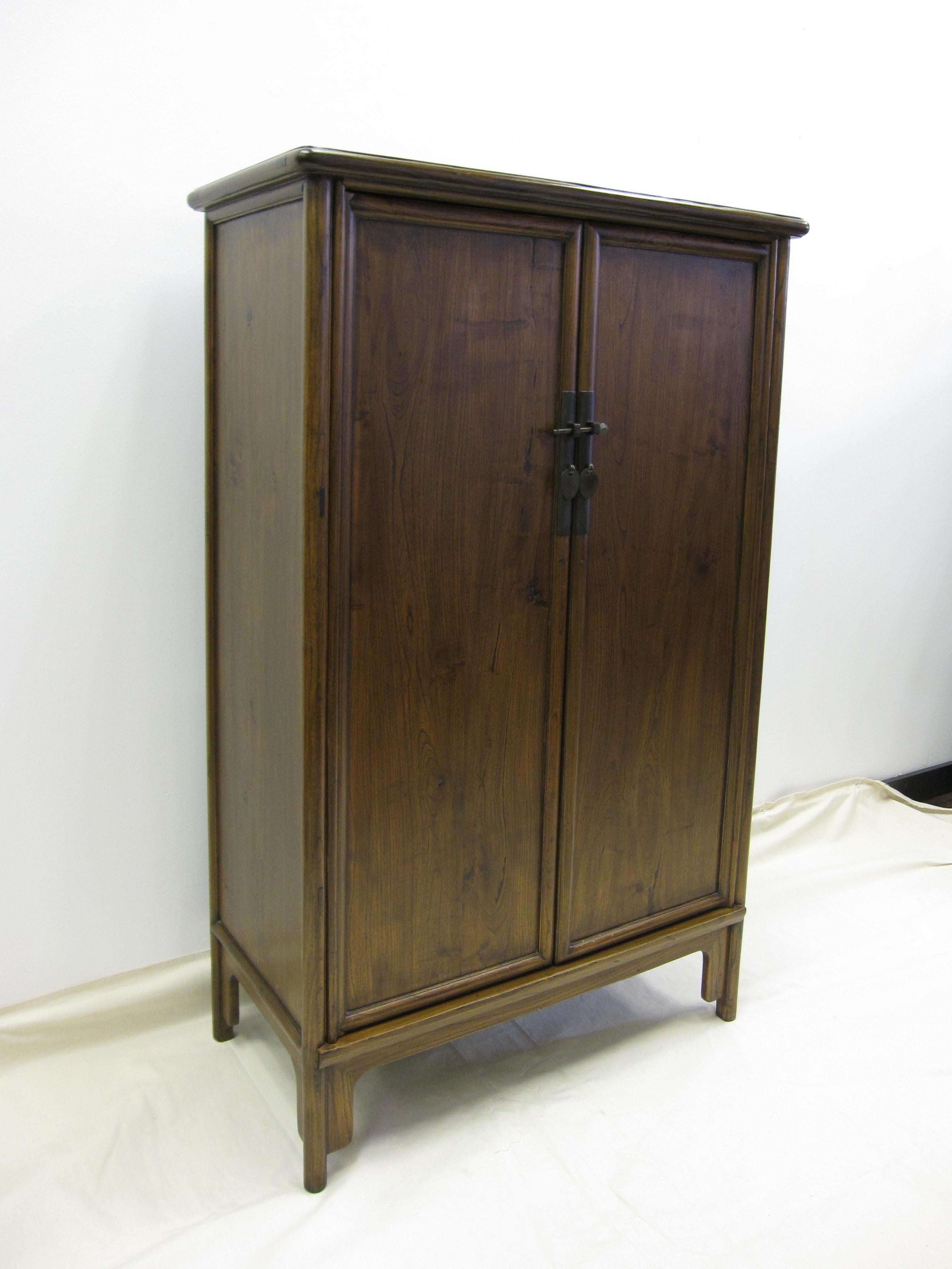 Antique Chinese tapered cabinet. Solid elm wood with round corner details, tapering 33 at the top to 34 at the bottom. Classic Chinese tenon and mortise joinery of a past century having a modernist and minimal style today.  Two drawers inside with a
