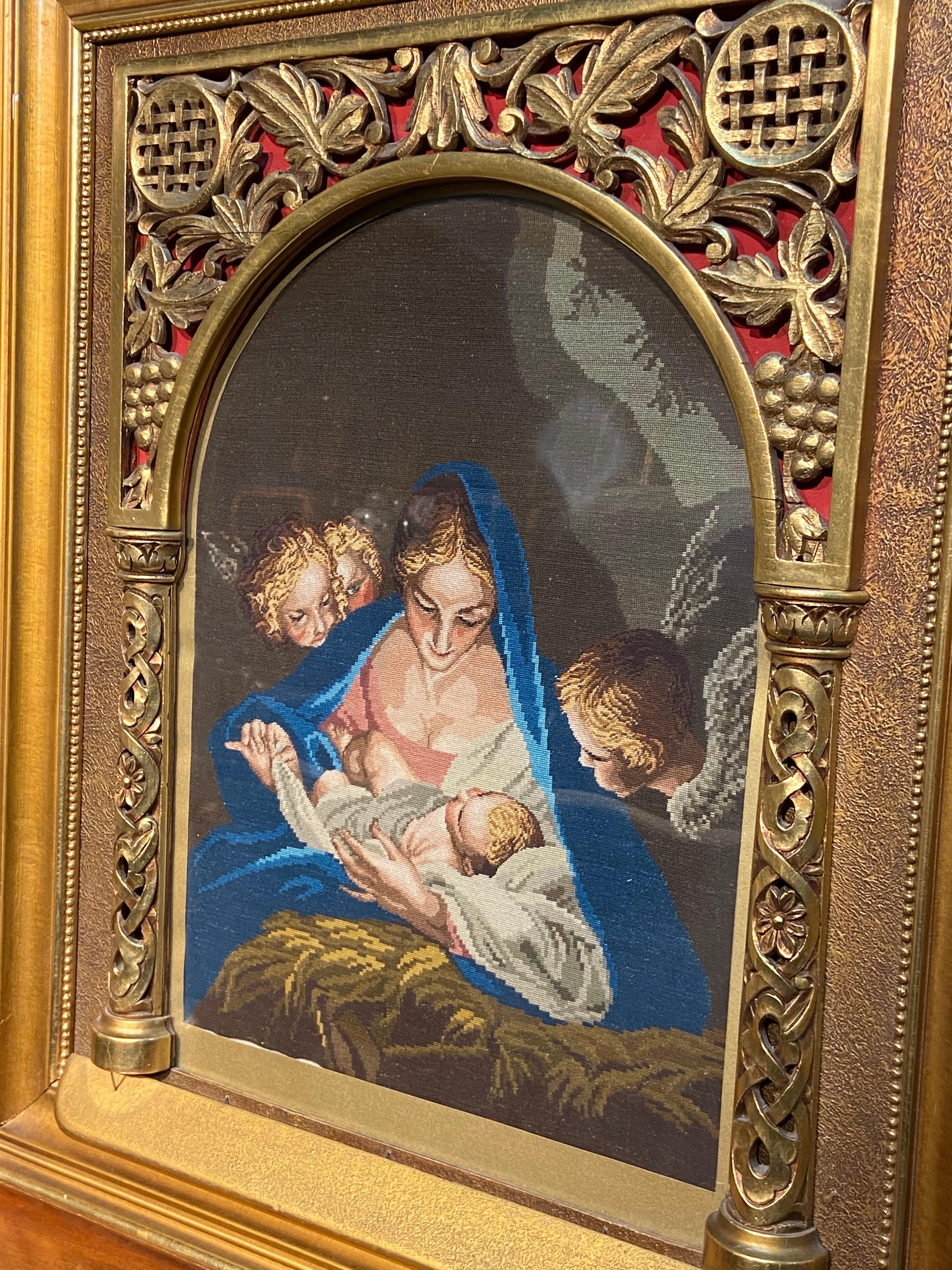 19th Century hand knotted wool tapestry representing Madonna with a Child in vivid colours and peaceful atmosphere with darling angels admiring the scene. The piece is framed in gilt wood hand carved wooden frame which creates an additional special