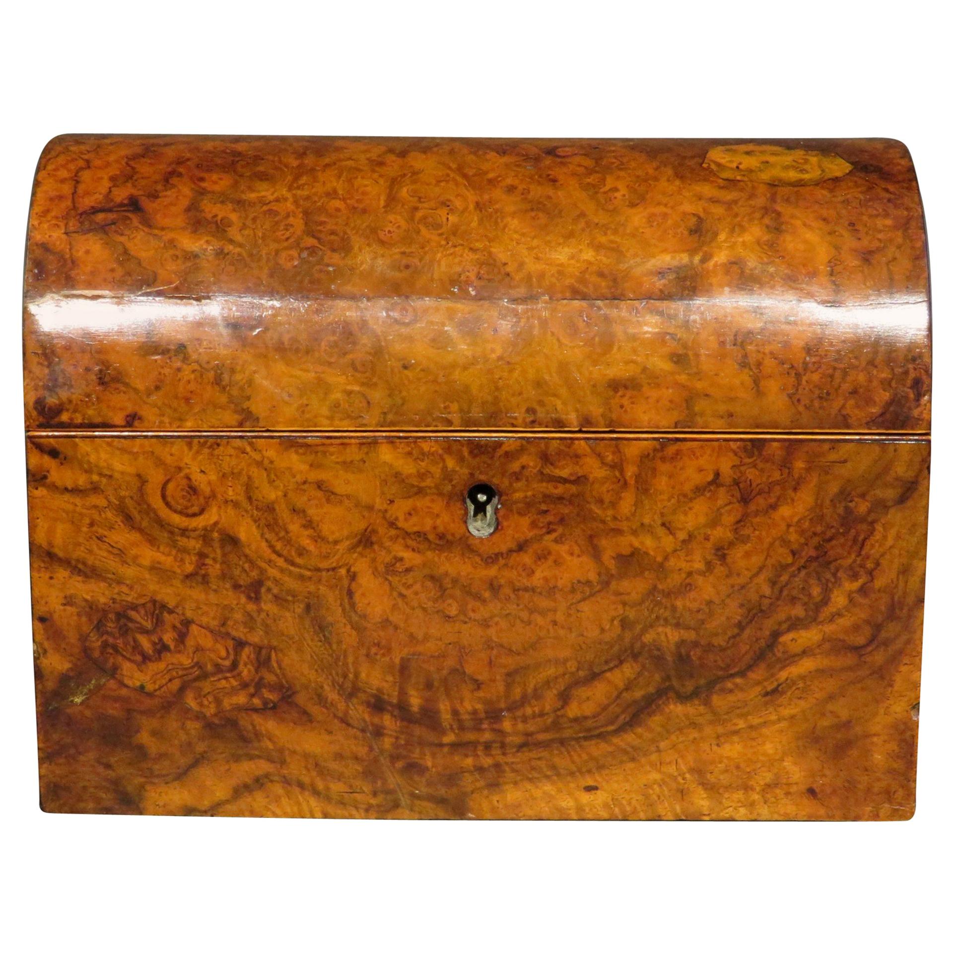 The highly figured domed case exhibiting a fine warm patina overall and opening to an interior housing twin tea canisters with confirming hinged lids and retaining its original functioning lock mechanism. This very handsome caddy is also accompanied