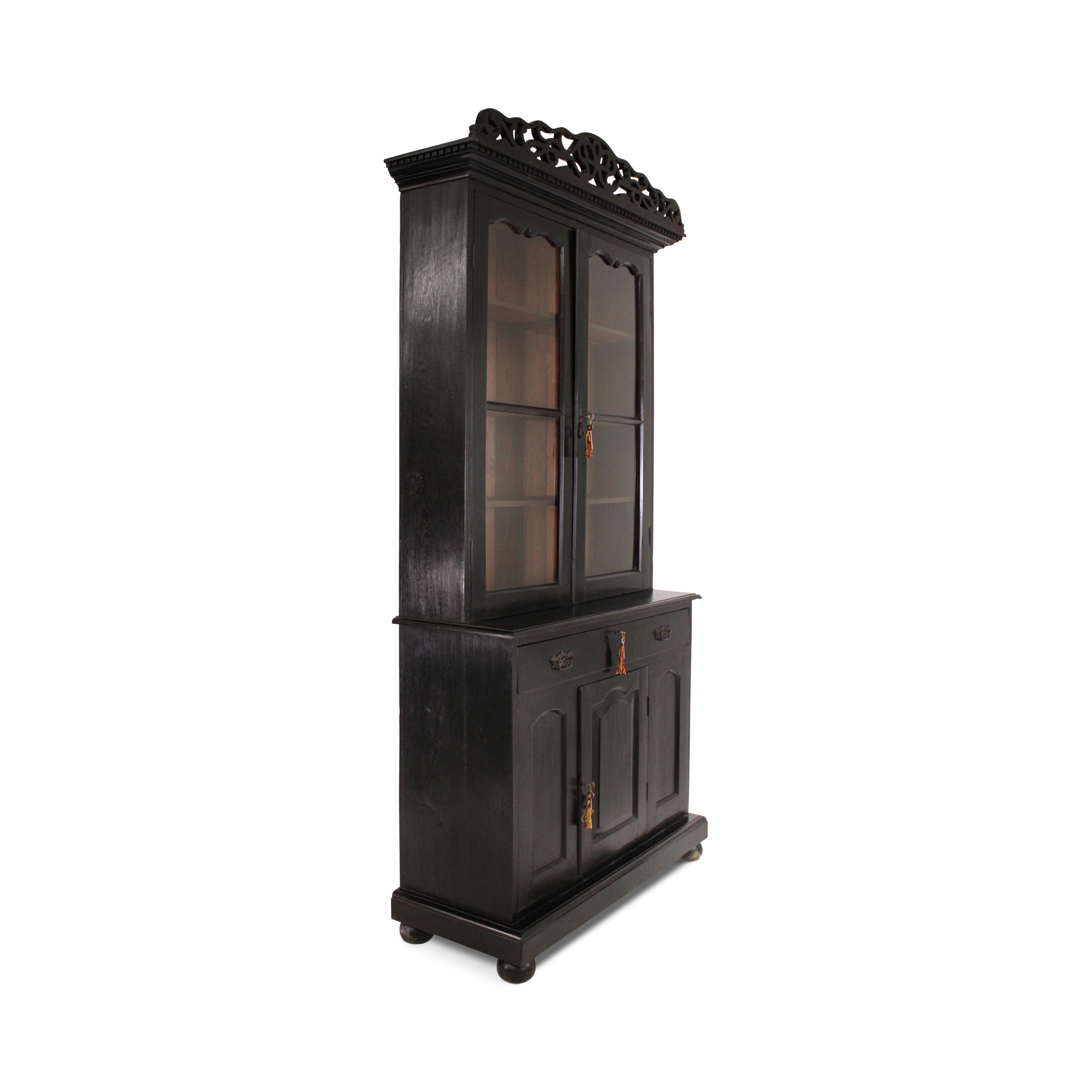 Un grazioso mobile o libreria in teak anglo-indiano. Conservando la sua lucidatura originale, mostra una bella patina e presenta una coppia di ante a pannello smaltate nella parte superiore, un cassetto centrale e un'anta a pannello nella parte