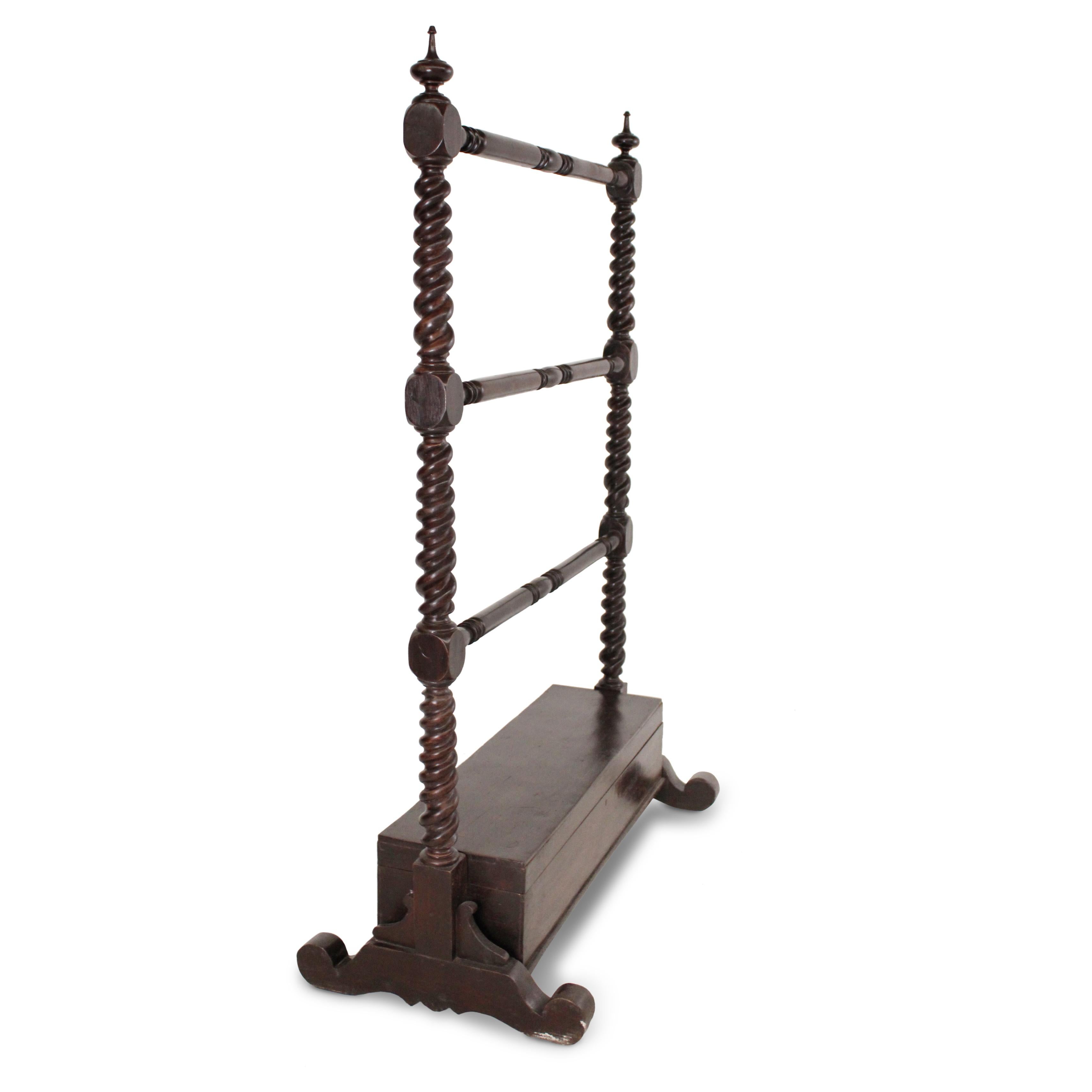 Un porta strofinacci o asciugamani in teak anglo-indiano dell'inizio del XIX secolo, caratterizzato dalla lucidatura originale e da una ricca patina. La rastrelliera è impreziosita da supporti laterali intagliati a torsione d'orzo e da barelle