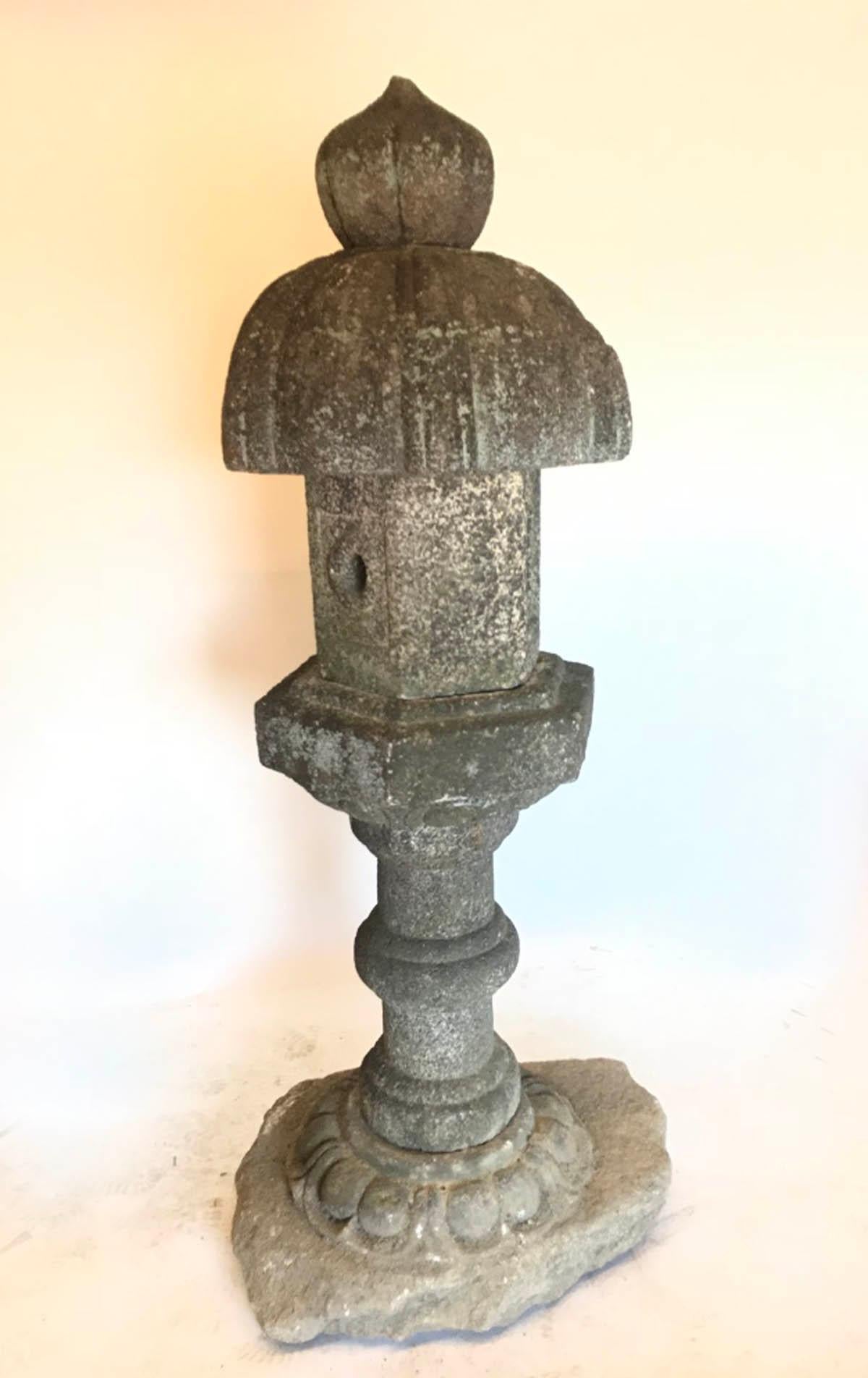 18th-19th century, Edo period Japanese stone (granite) lantern, carved. Base bottom piece remains attached on the stone it was carved from which gives it a natural transition from nature to lantern. It consists of six pieces. A light or candle is