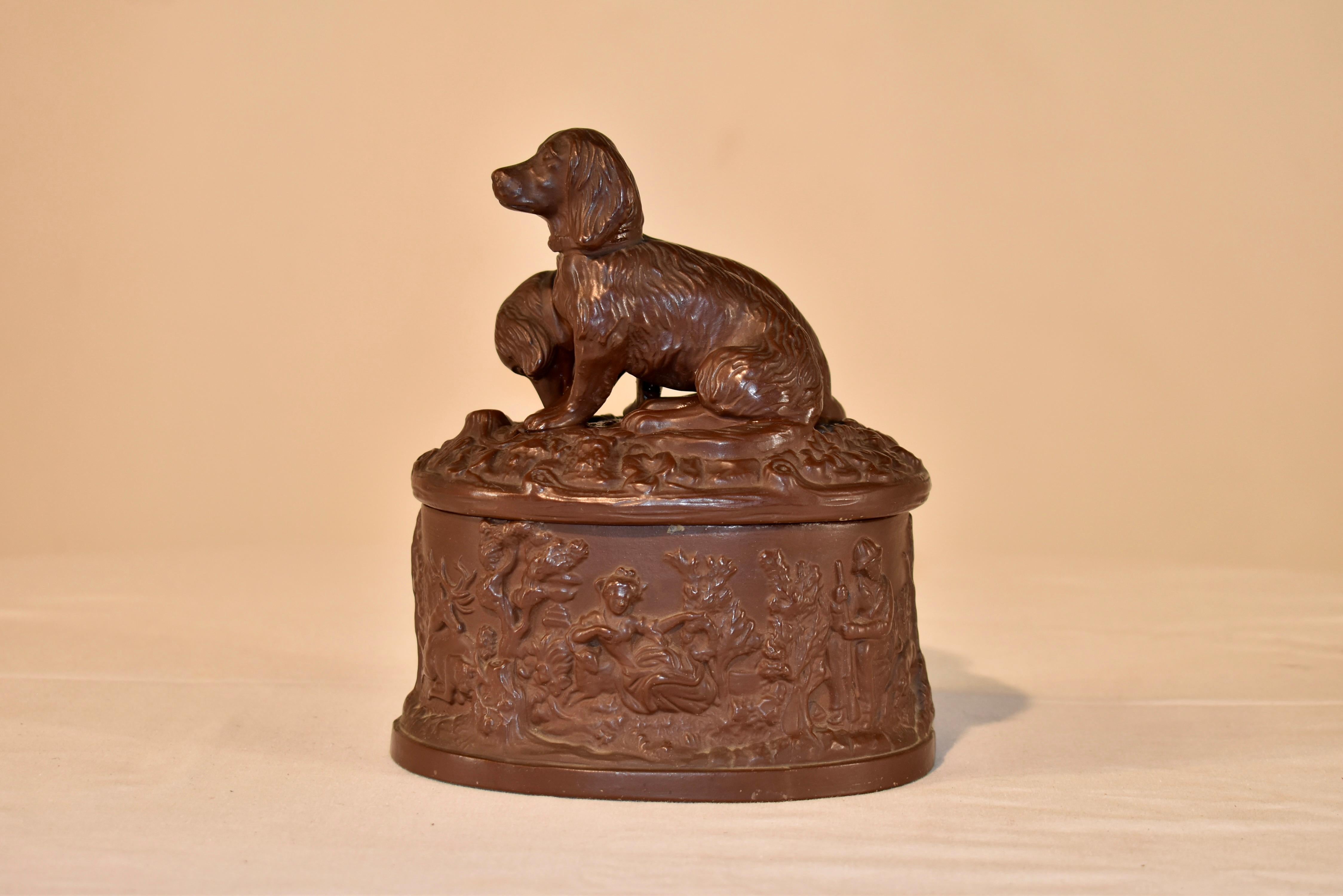 19th Century terracotta lidded box from Austria. There are two lovely molded dogs on the top, which are used for the handle. The base has a molded garden scene depicting animals and people interspersed with trees and foliage. Marked on the base EGW.