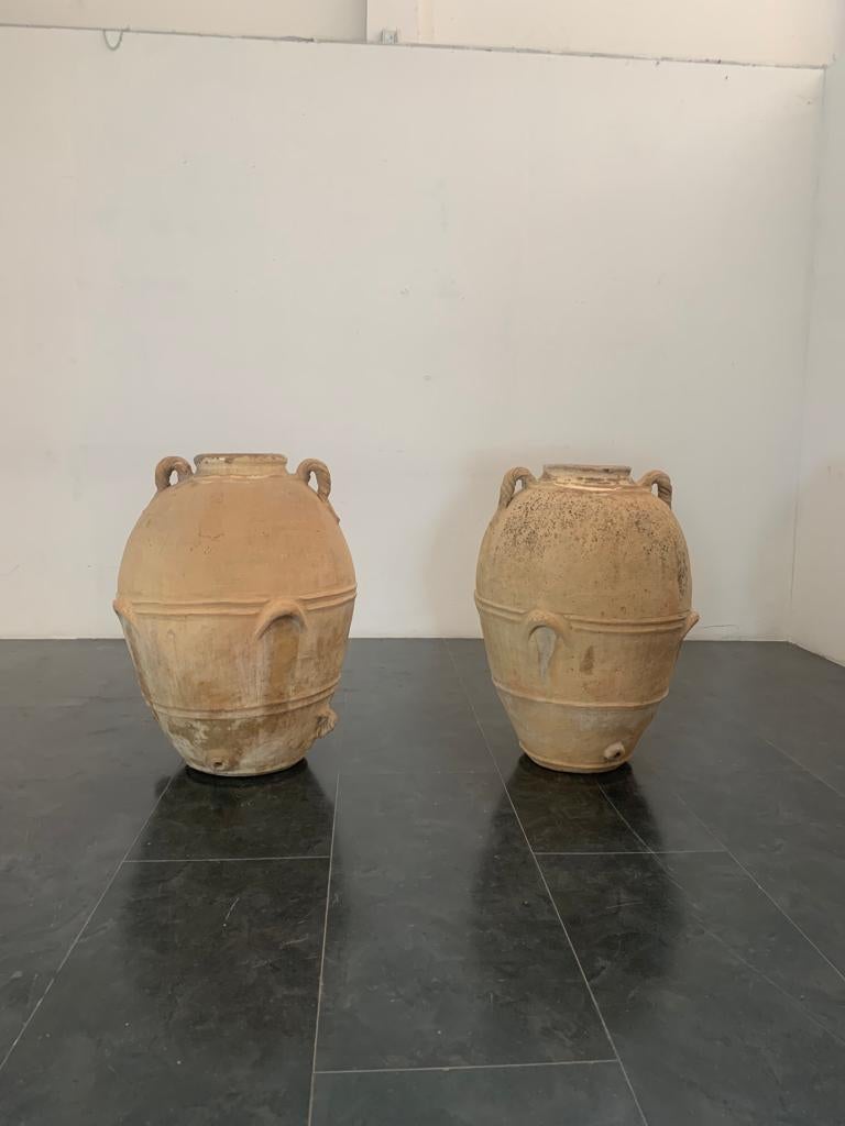 Coppia di antiche brocche in terracotta. Le dimensioni differiscono leggermente a causa della lavorazione a mano: il primo misura 100 x 70 cm, il secondo 105 x 73 cm circa.
L'imballaggio con pluriball e scatole di cartone è incluso. Se è necessario