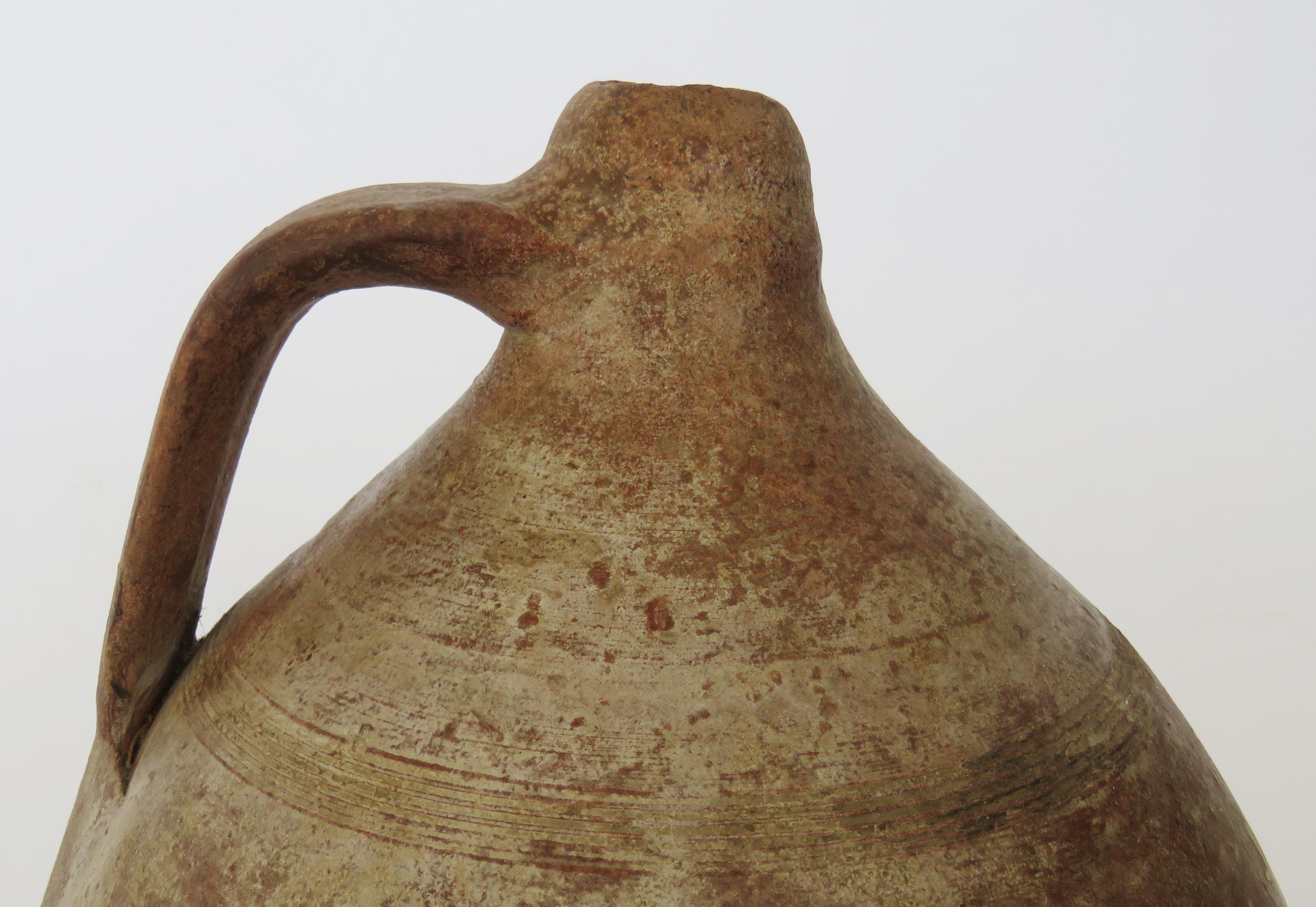 Rustic hand coiled jug with bottle neck and handle.