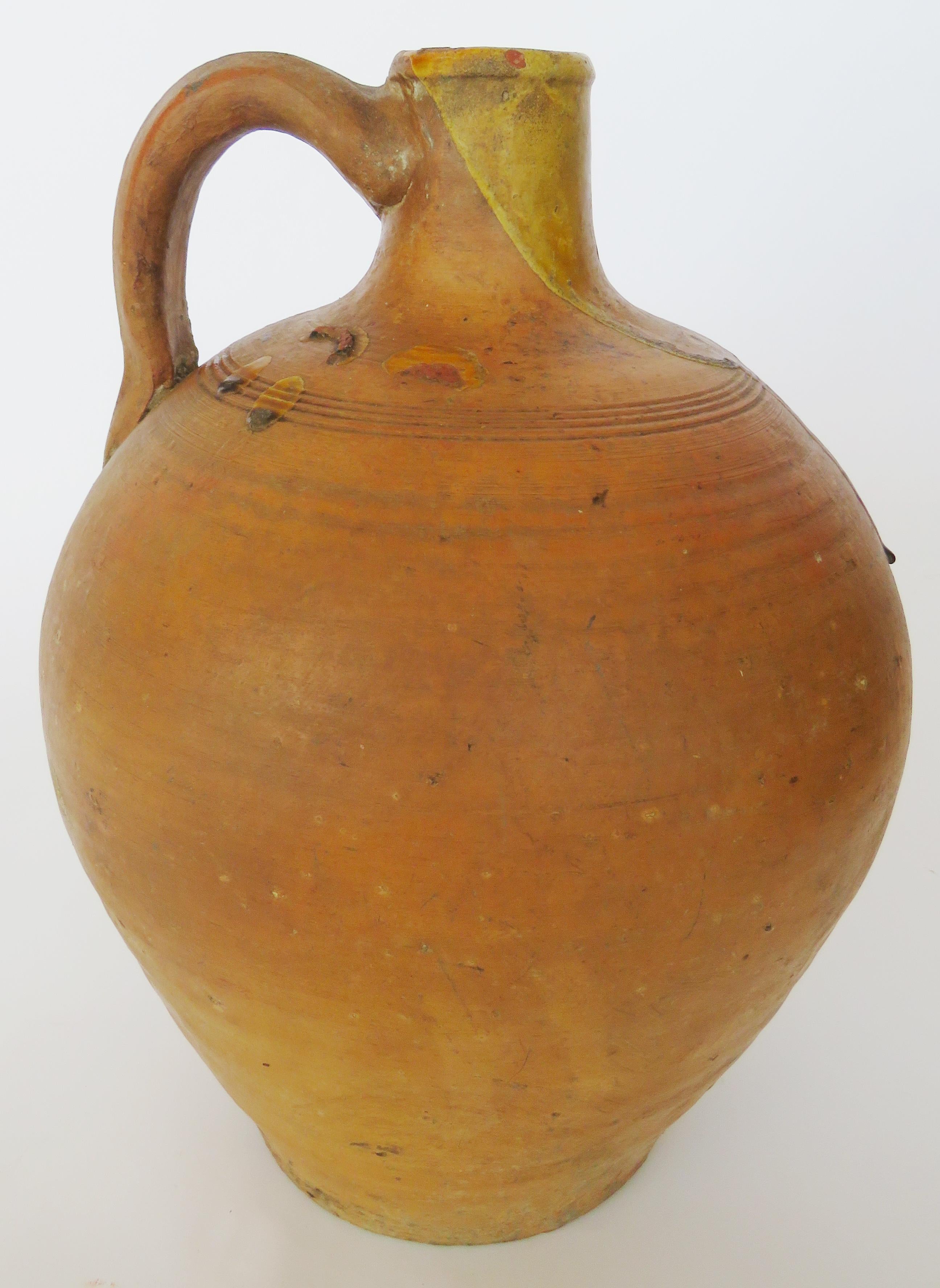 Hand coiled jug with slim glazed neck and handle.