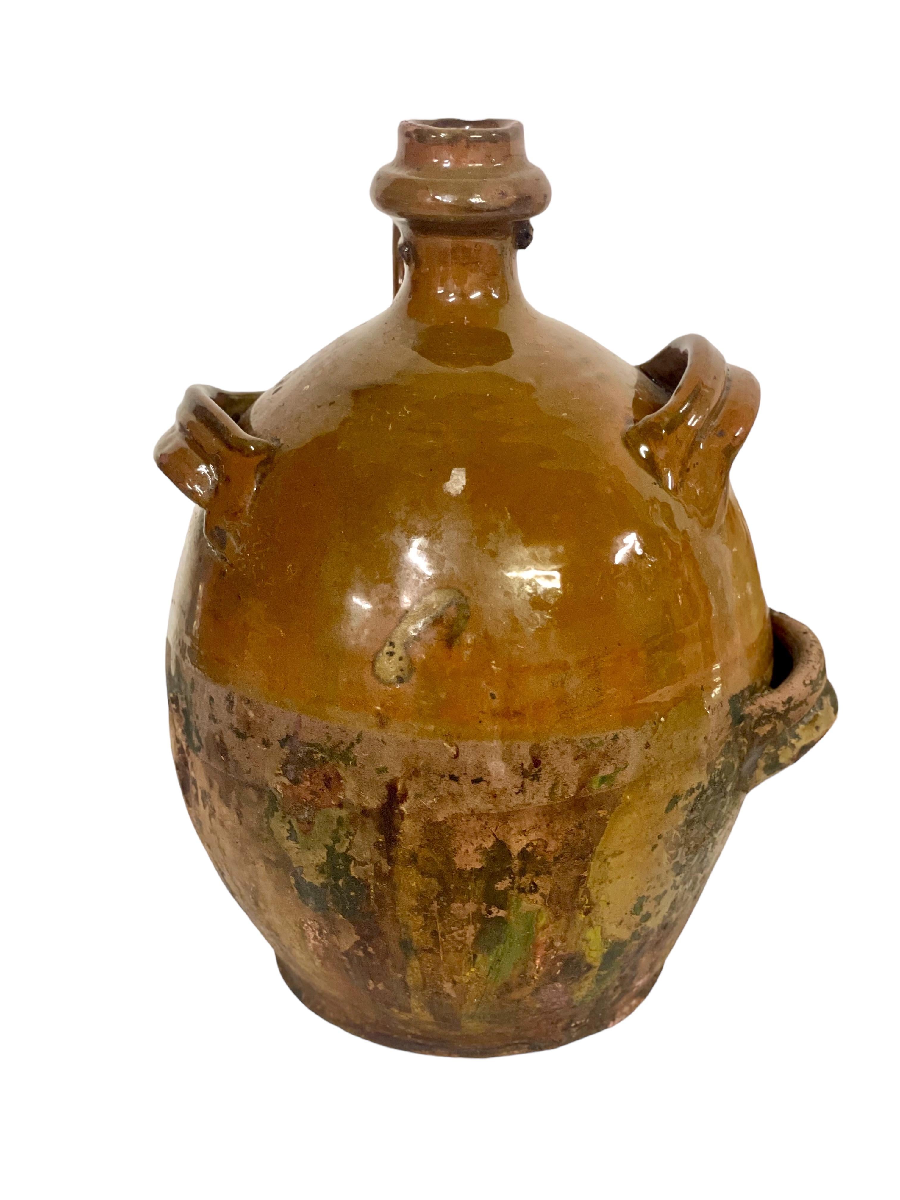 A gorgeous antique terracotta olive oil jar, or gourd, dating from the 19th century, complete with shaped, narrow top spout and side handle, as well as three additional handle 'straps' to keep the vessel steady while pouring. Originating from