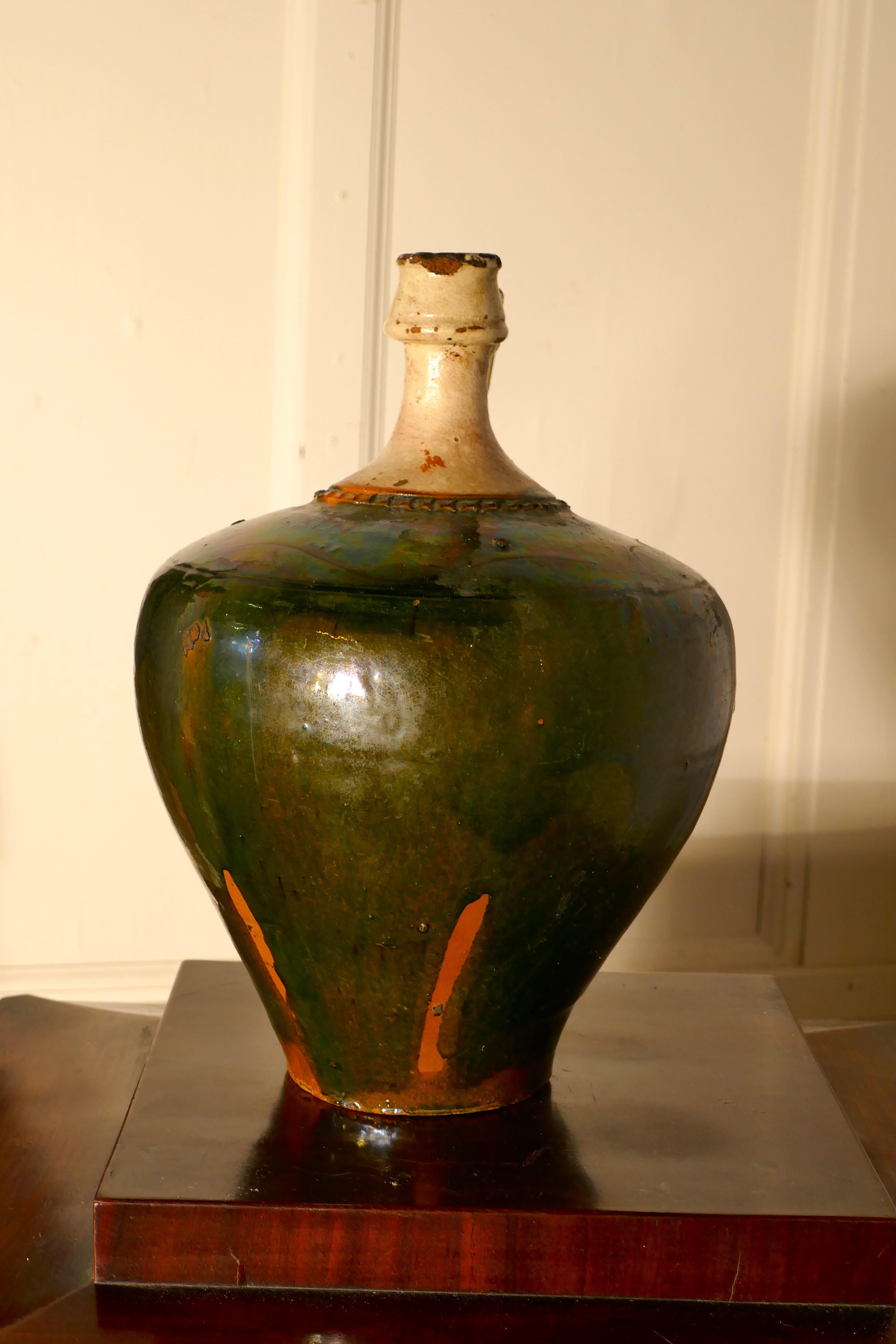 19th century terracotta olive oil Jug from Portugal.

A wonderful Portuguese antique olive oil jar, this piece has a beautiful shape, handle to one side and a very attractive dark green glaze, not perfect but in very good condition for its age