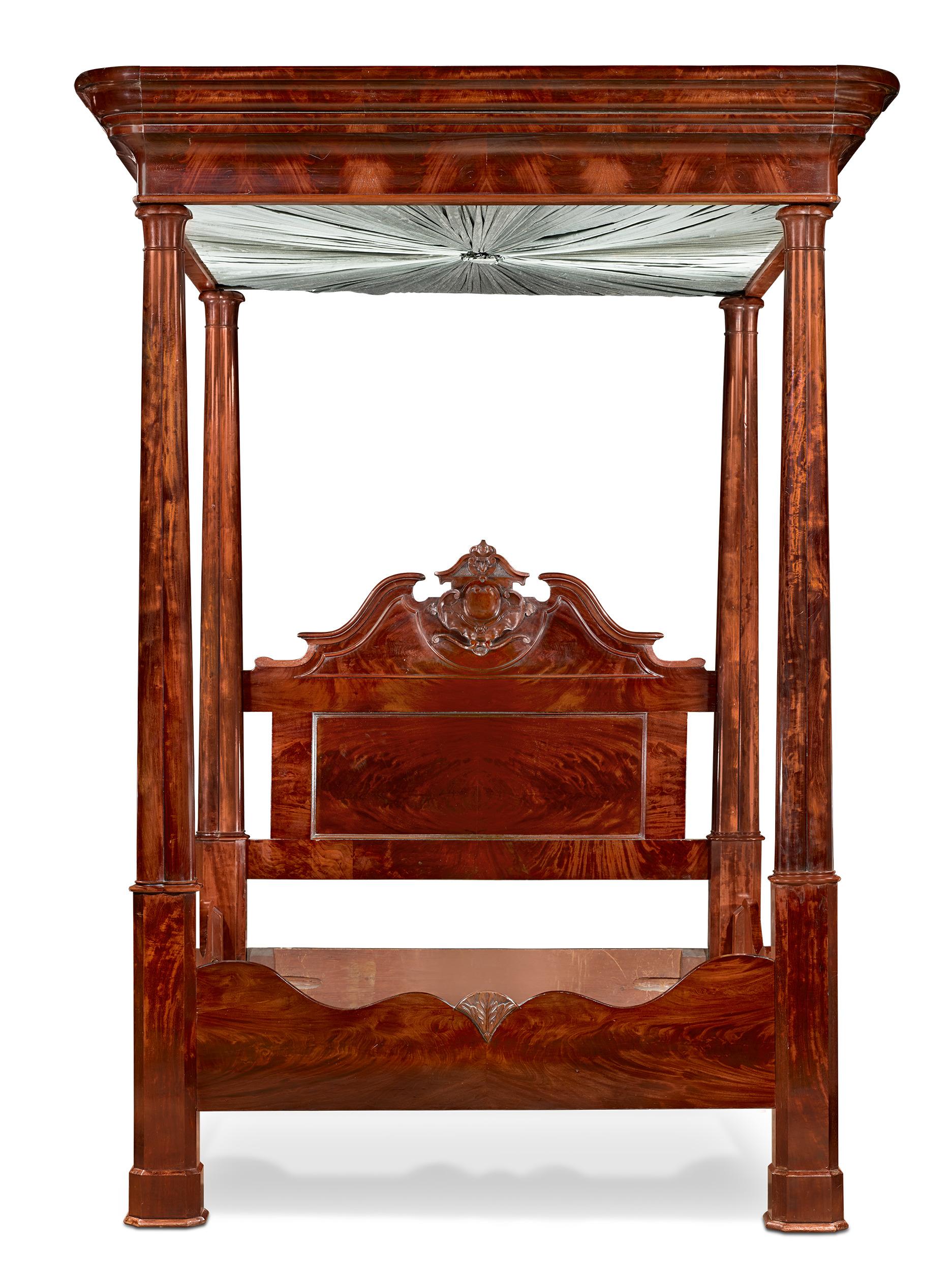 This lavish American tester bed exhibits superior craftsmanship and detail. The design is embellished with elaborate carvings on the headboard and sides. The stunning wood grain enhances the appeal of the artfully crafted design. A canopy of folded