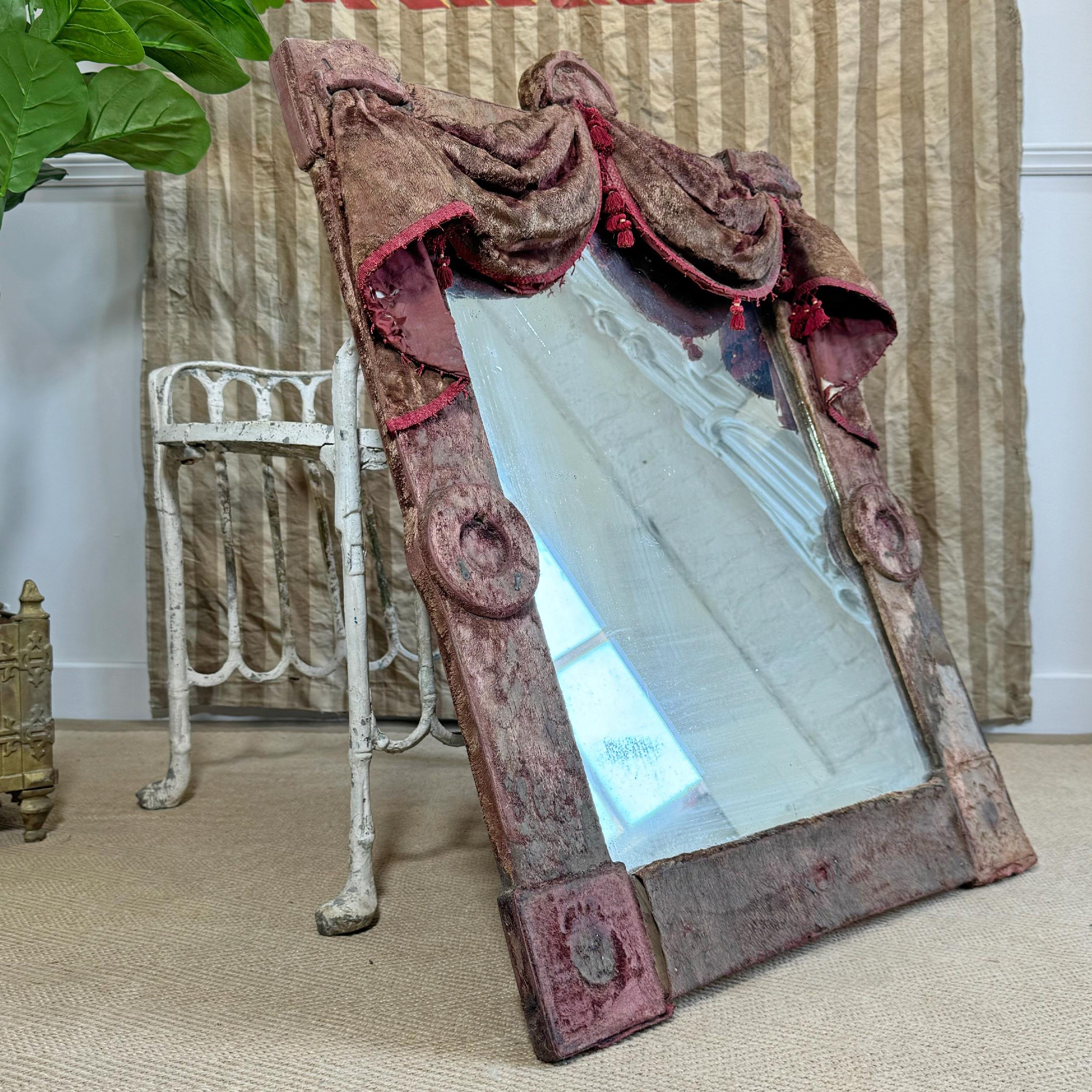A beautiful and theatrical 19th century Victorian burgundy velvet mirror, the swags and drapes give the impression that the mirror is almost a stage. The velvet is time worn and faded, dramatic and captivating, a true interior designers