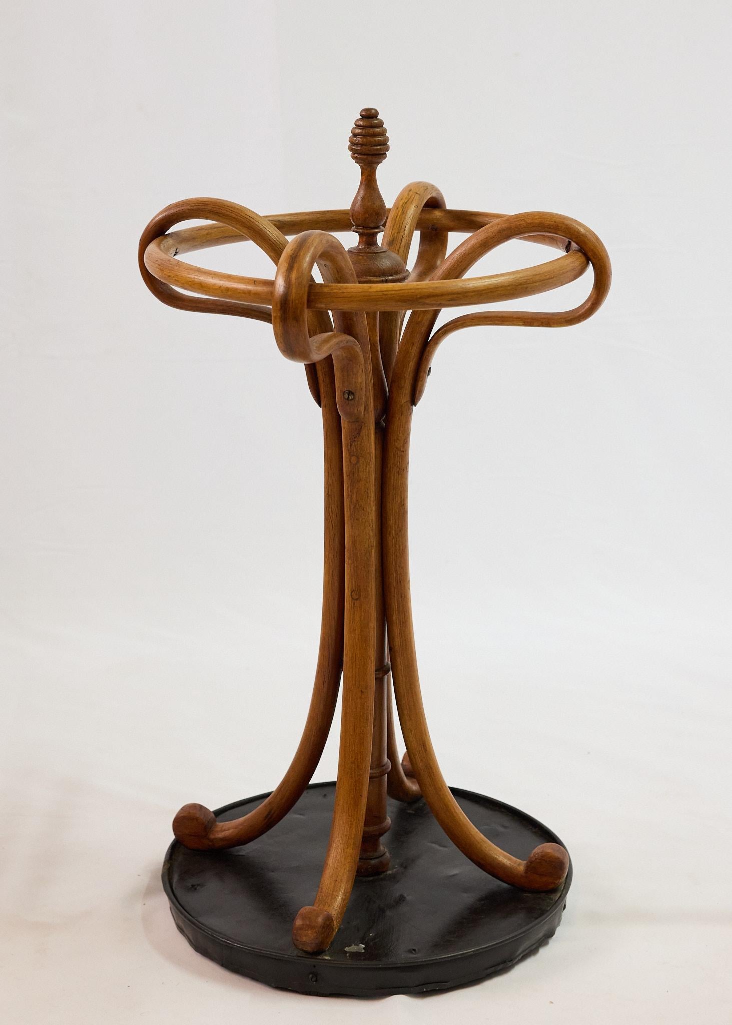 Portaombrelli classico Thonet di fine Ottocento in legno di faggio, ottimo esempio dell'innovativa tecnica di costruzione sperimentata da Michael Thonet. 
Il supporto centrale, coronato da una ghiera, è tornito e circondato da un anello di legno