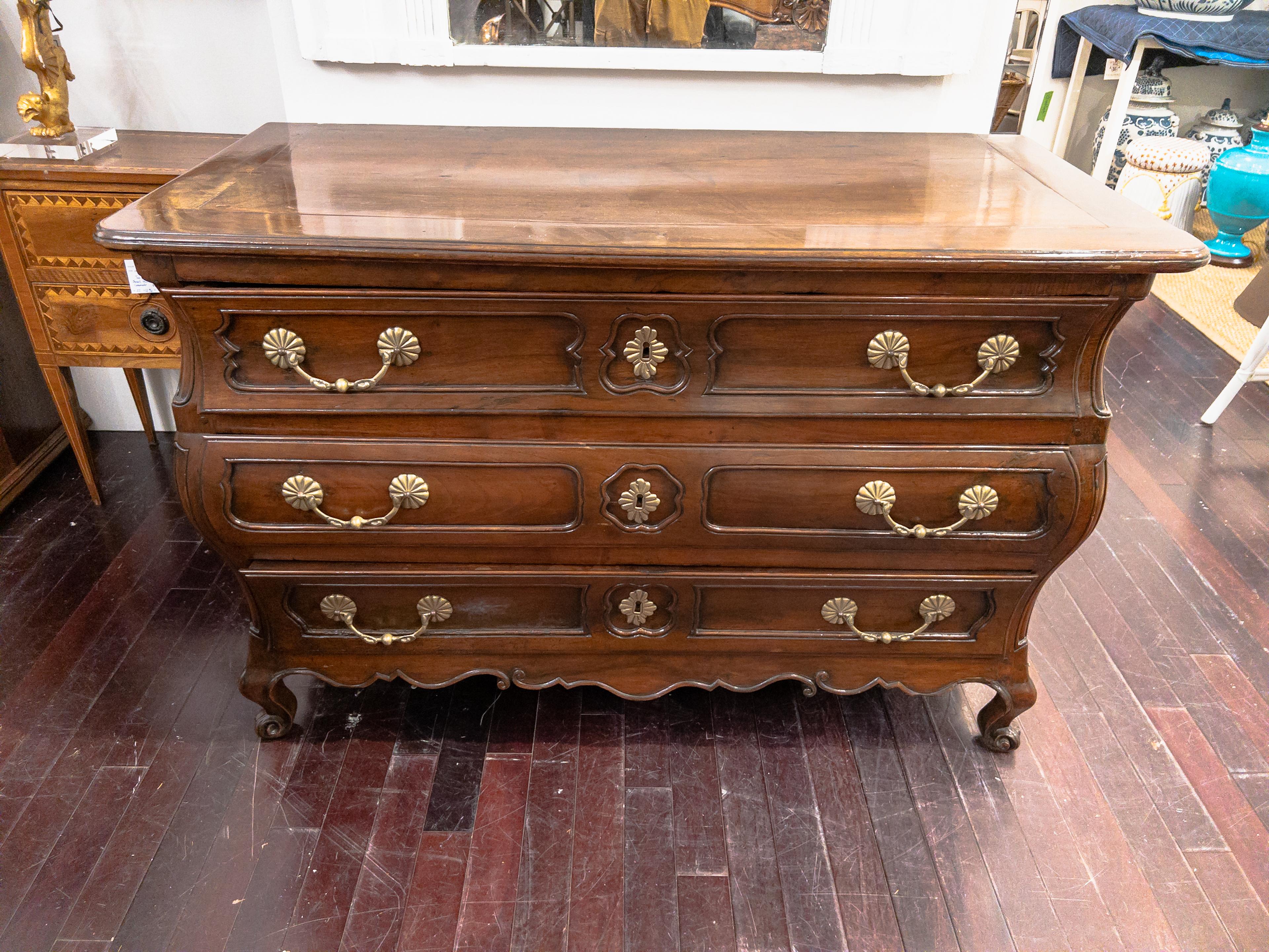 19th Century Three Drawer Provincial Commode, with brass hardware, shaped curved front and sides, opening with 3 drawers in three rows. The highly curved sides are paneled and molded. It rests on 4 carved feet.