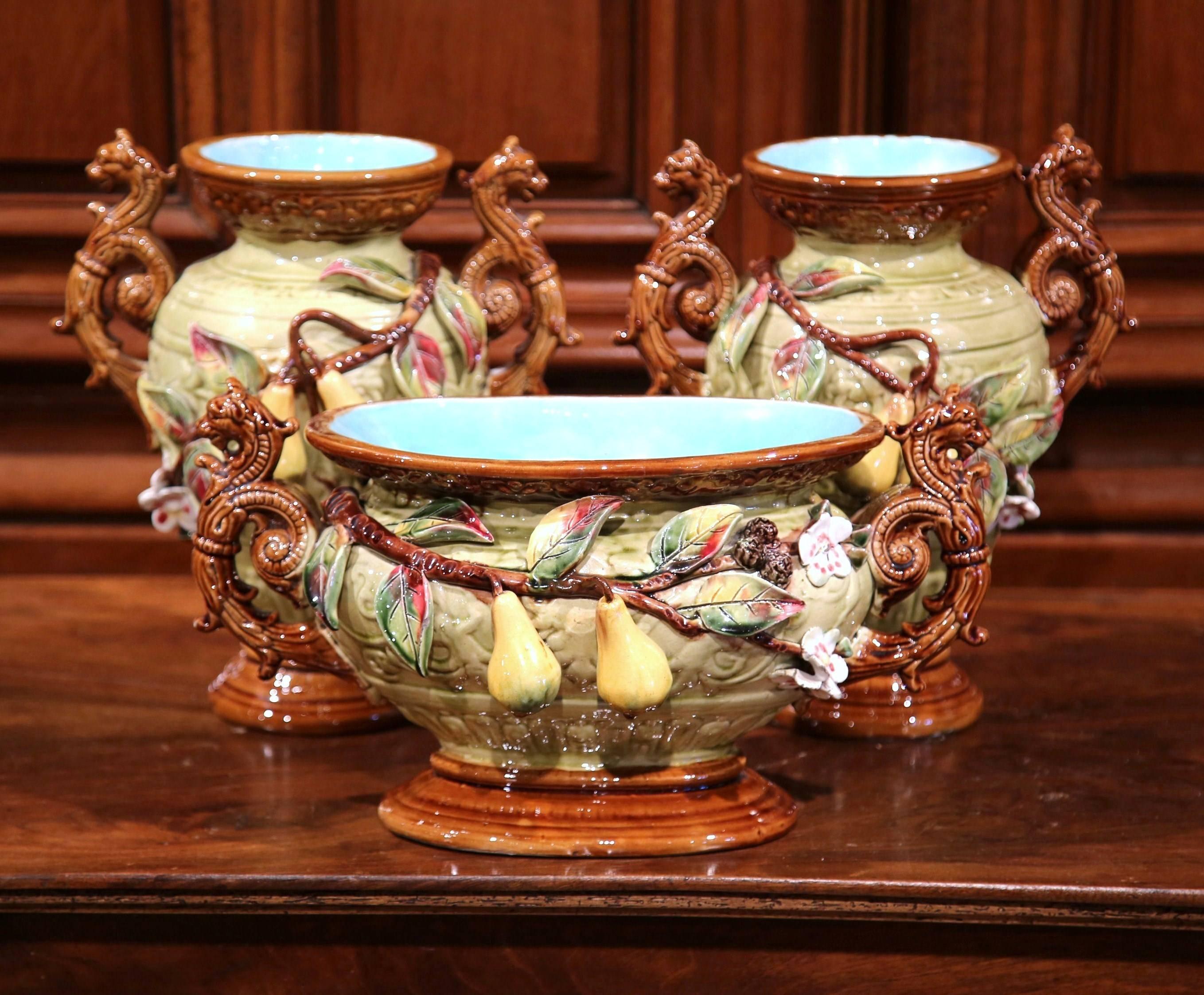 This beautiful three-piece set was crafted in France, circa 1880. Made of two Majolica vases and a matching planter, this ceramic set is a Classic example of barbotine artistry. The sculptural porcelain pieces feature yellow pears in high relief