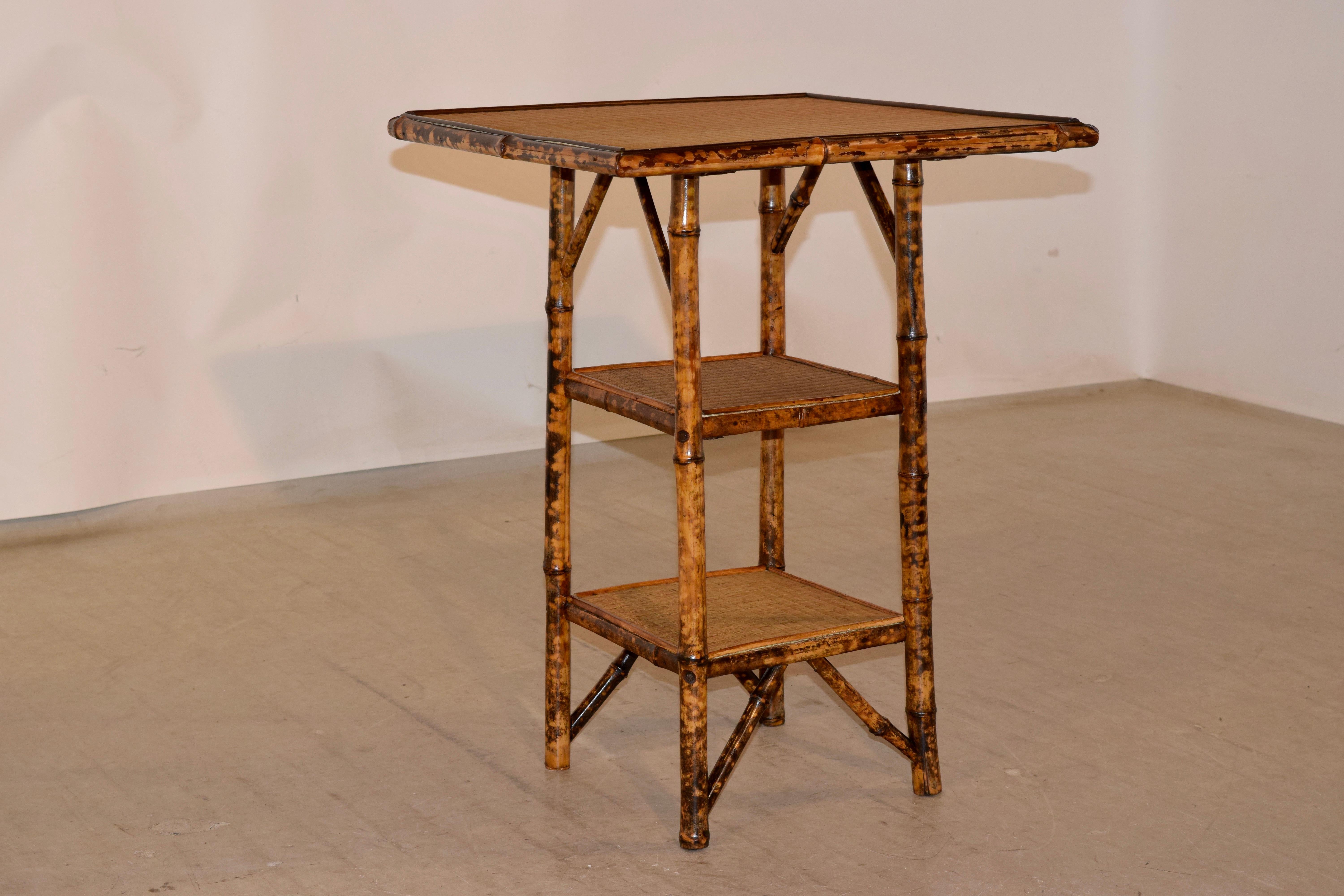 19th century tortoise bamboo table from France with rush covered top and two lower shelves.