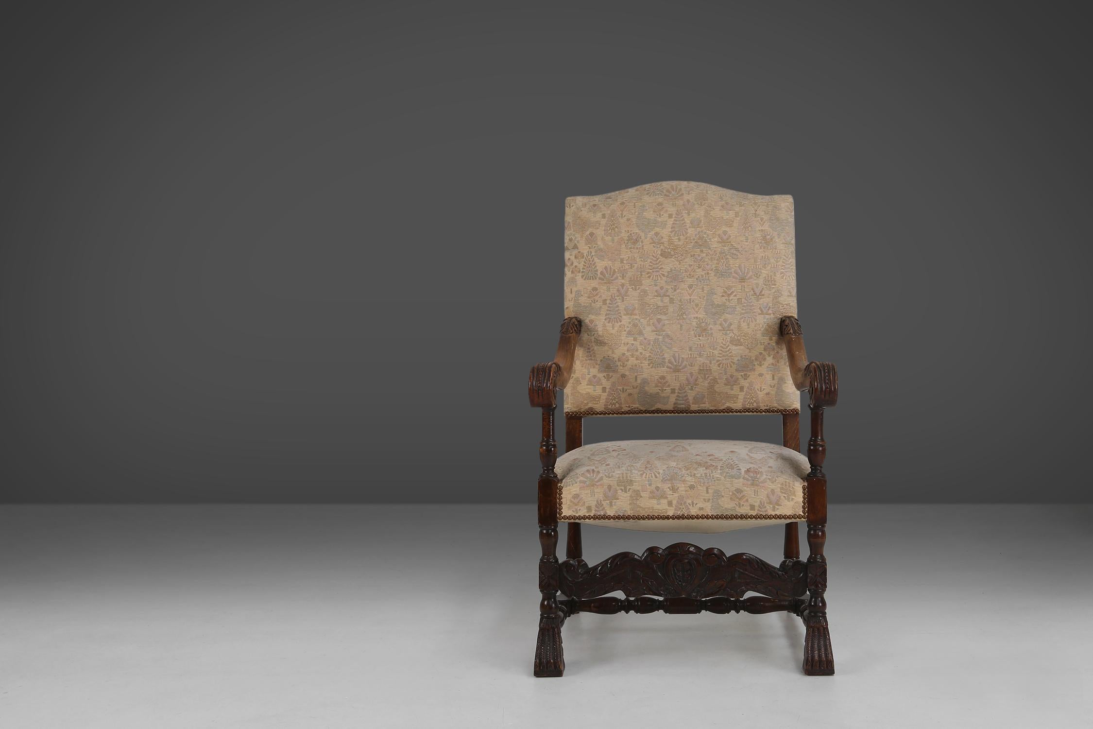 This 19th-century magnificent throne chair is made of oak wood and upholstered in fabric with an ornate motif.

The wood is decorated with fine Renaissance-style sculpting, which shows craftsmanship and taste. The chair has a high back and armrests,