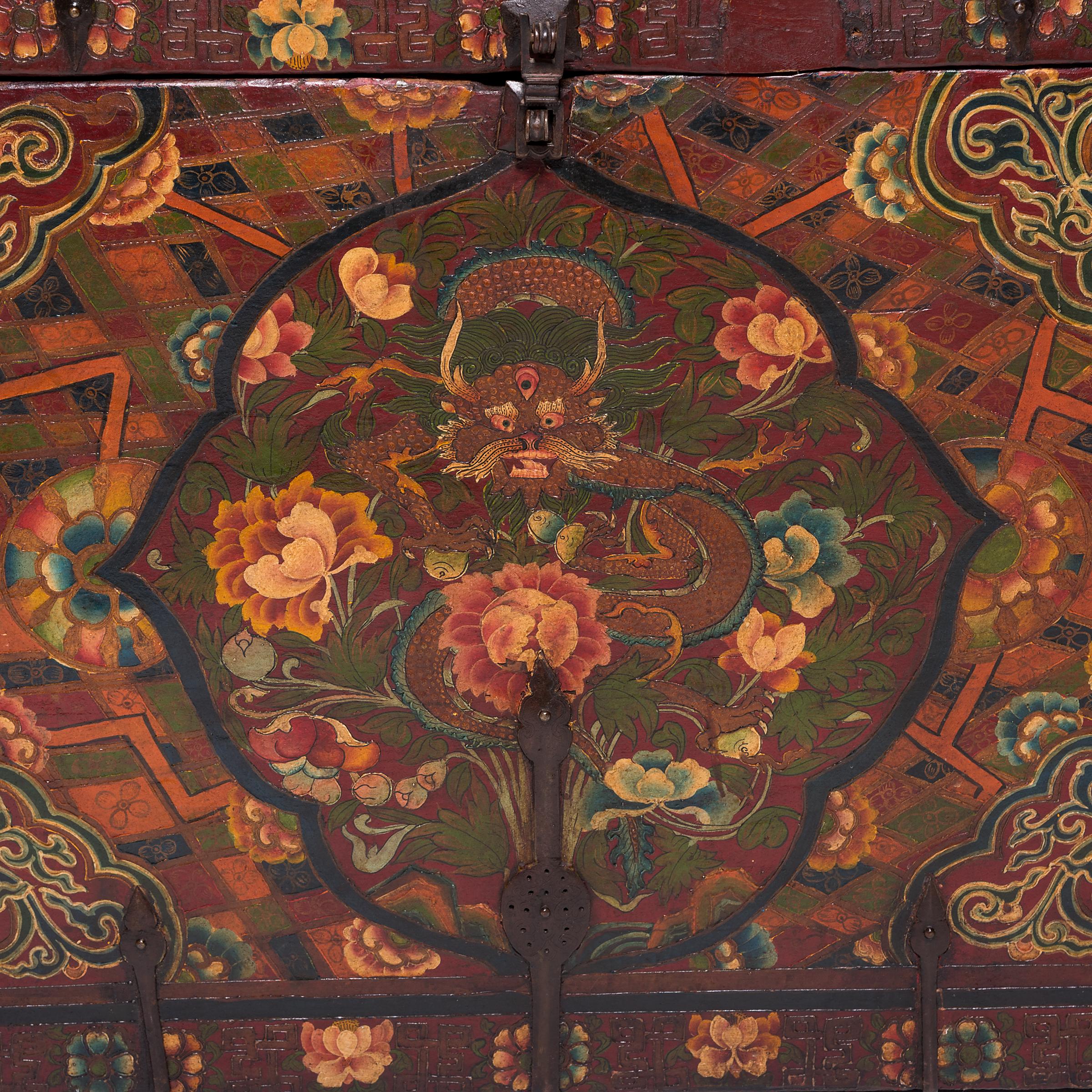 Ensconced in a cartouche filled with flowering peonies, a glorious dragon stares out from his heavenly realm on this brilliantly painted trunk. An early example of painted Tibetan furniture, the chest is lavishly decorated with emblems symbolic of