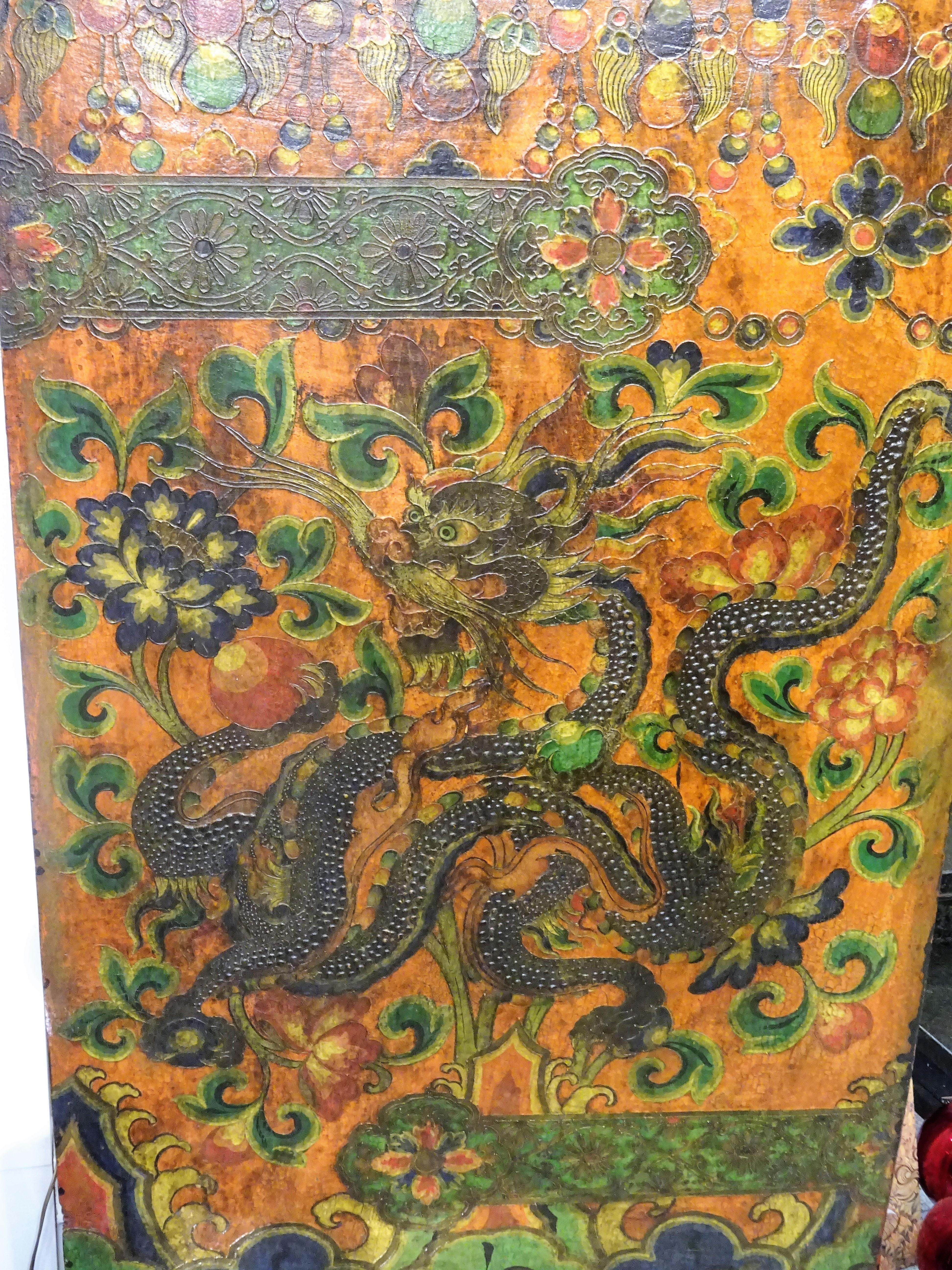 One of a kind Tibetan wooden door on a wooden base as a sculpture, could be hung on the wall too.
On a red backround paprika represents a dragon among camelias and different oriental symbols, hand painted in relief with natural pigments, green, blue