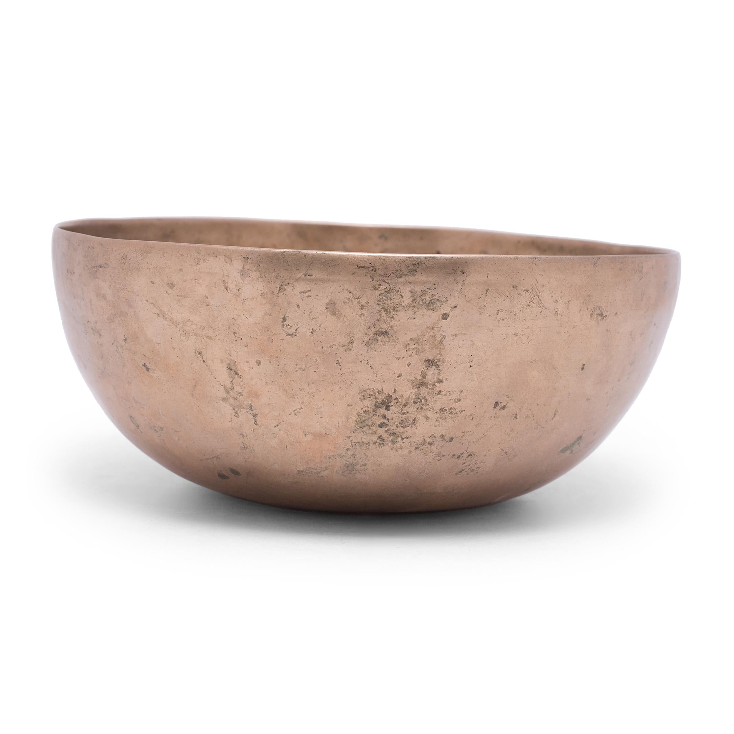Dated to the mid-19th century, this singing bowl was traditionally used for meditation. It is hand-formed from eight mixed metals including copper, tin, iron, lead, zinc, gold, silver and mercury. The eight metal alloy together produces a deep, rich