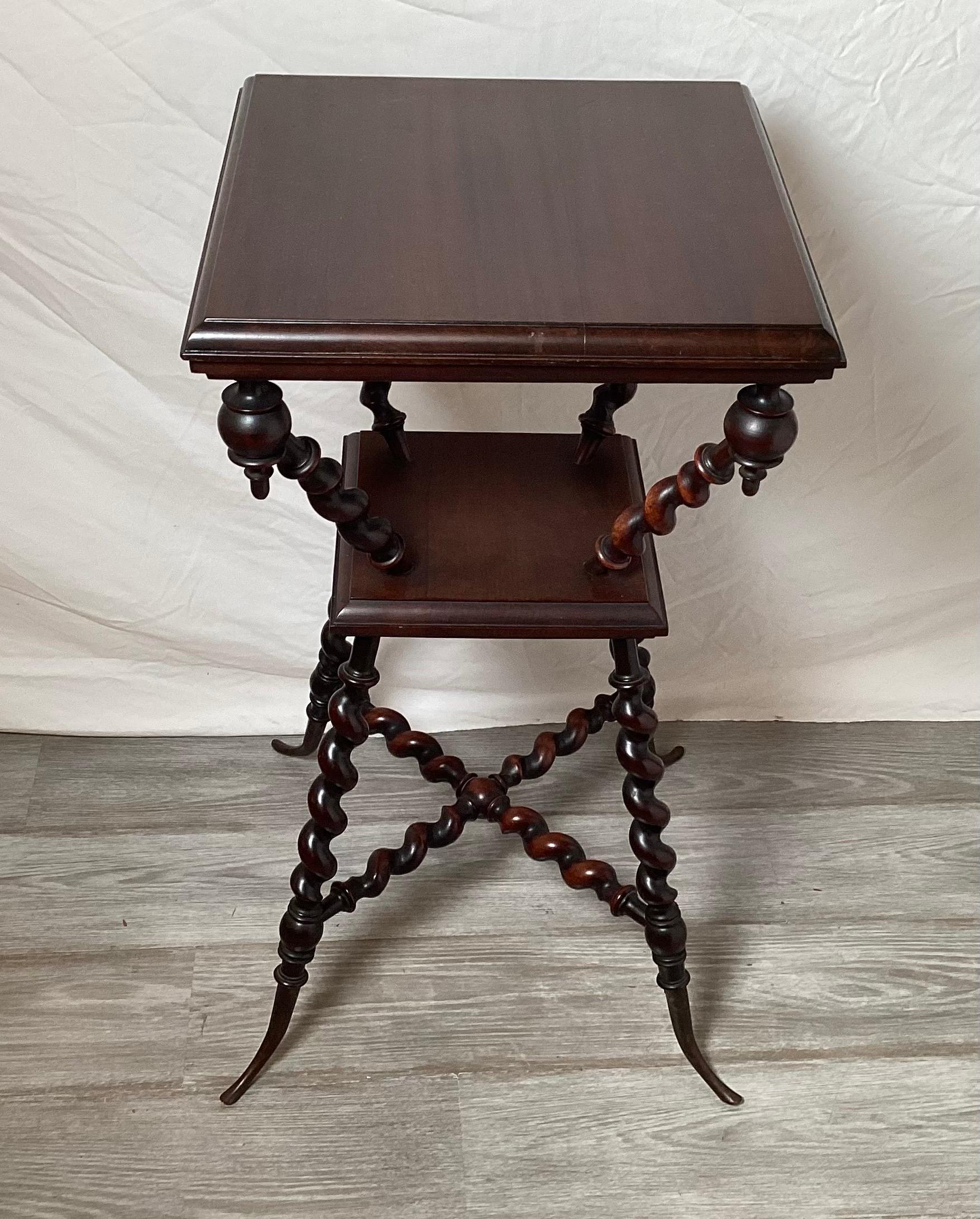 A dark mahogany hourglass shape barley twist tiered side table by Merklen Brothers.  The original finish with elegant turned legs that end in a flared tapering foot with brass caps. Overall nice condition with minor signs of age and use 