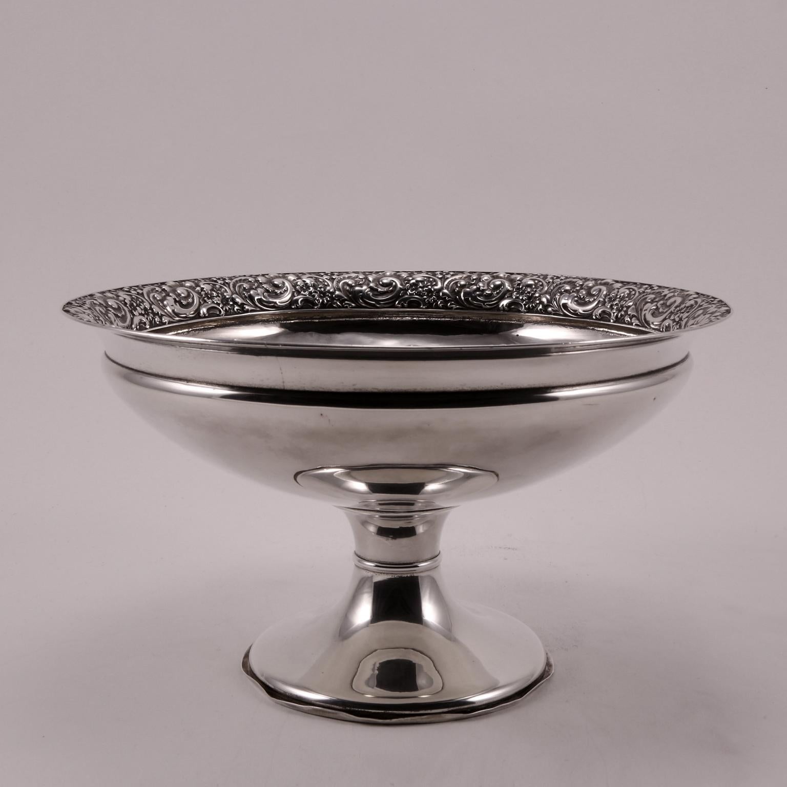 A rich decorative band, floral-themed, thickly covers all the edge of this riser.
The base is decorated with a slight ripple, creating a balanced harmony between the various parts.
Produced by Tiffany & Co. Inc. New York, 1898.
