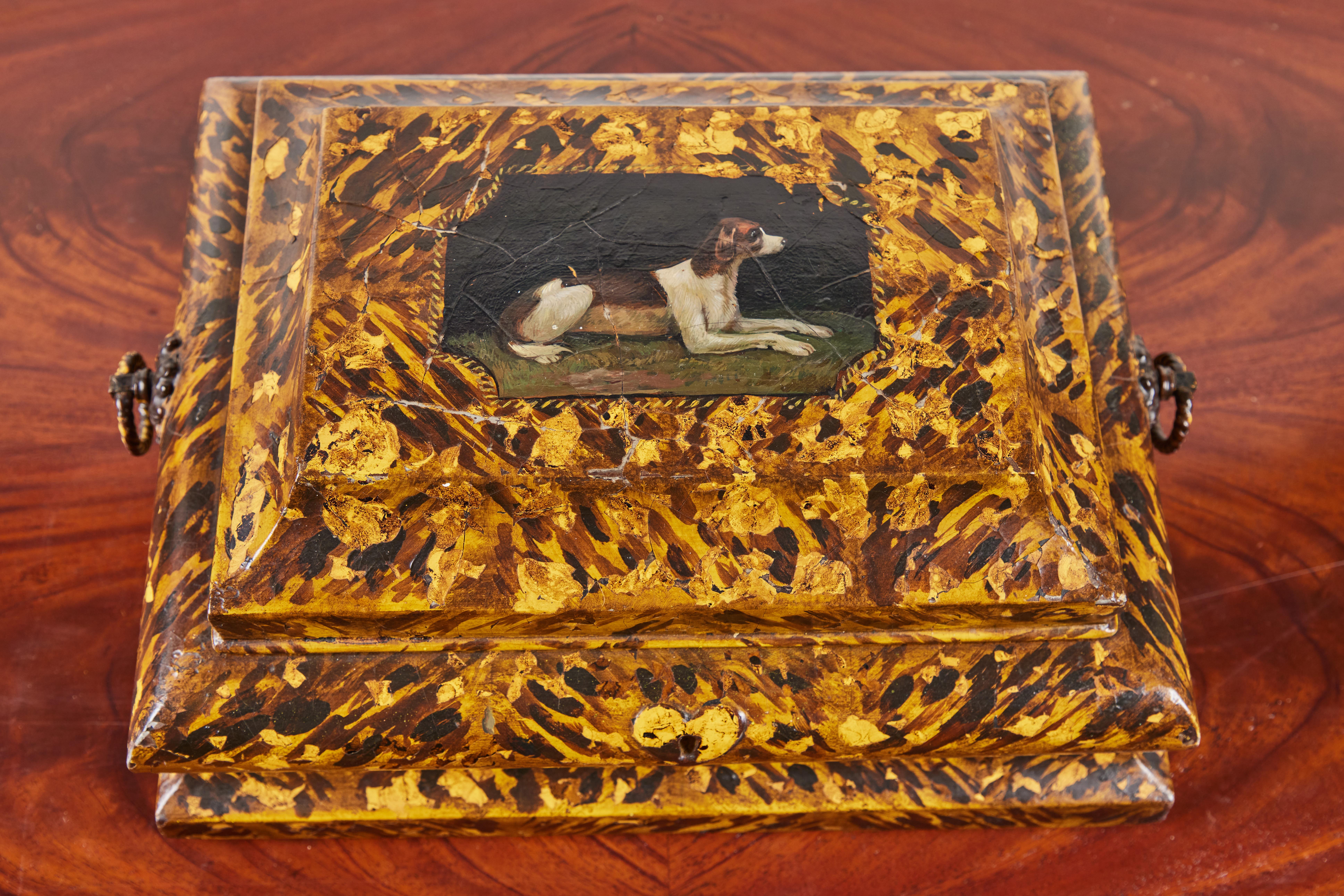 Fabuleuse boîte aux lettres ondulée, datant de 1820, de style anglais, à charnière, peinte à la main en fausse tortue. L'intérieur avec un miroir qui cache un compartiment secret. La partie supérieure est ornée d'un camée avec un chien peint,