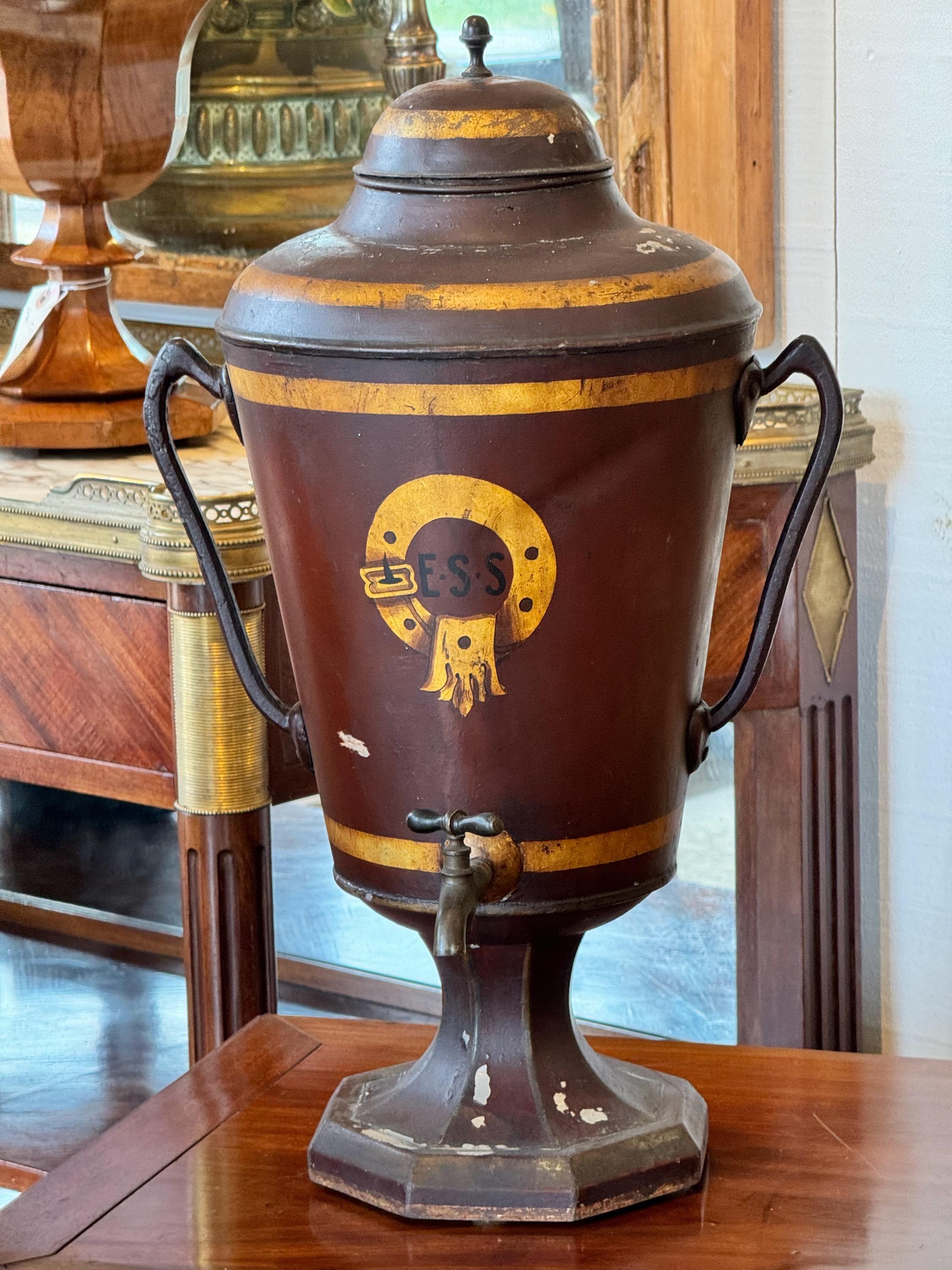 Une urne à eau en tole décorée avec beaucoup de charme. Une belle pièce centrale pour une console ou une table.