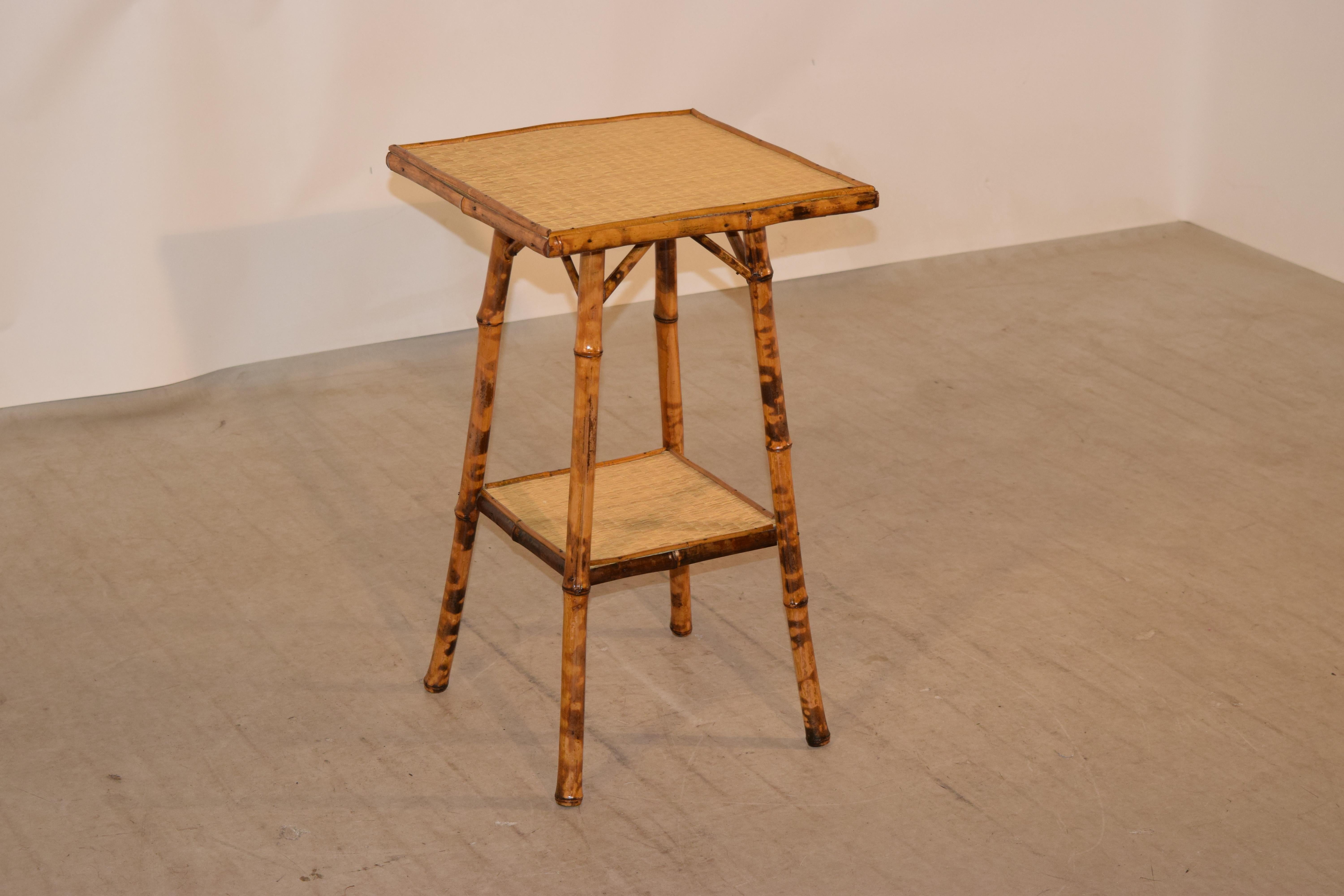 19th century tortoise bamboo side table from France with a rush covered top and lower shelf. The table has splayed legs.