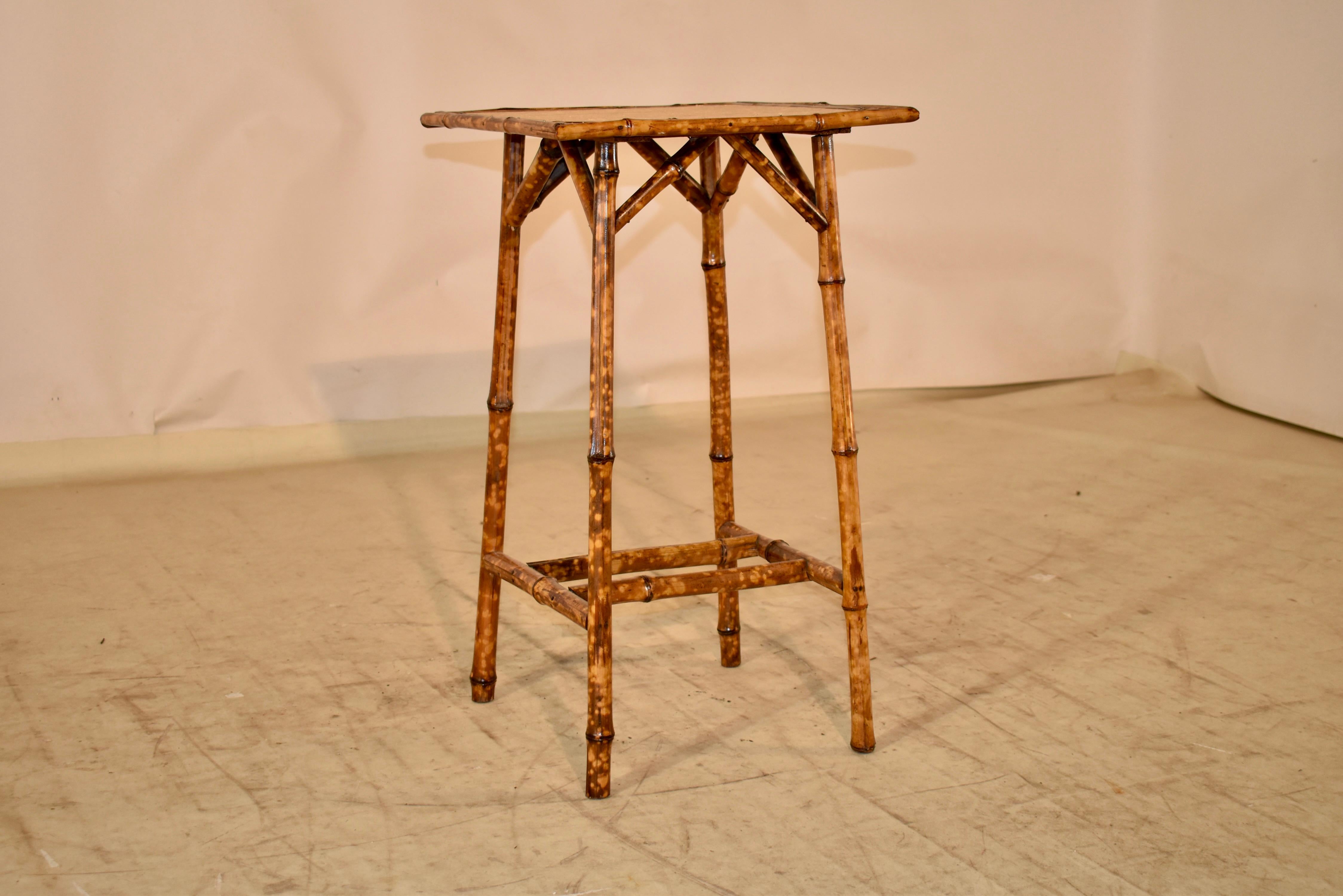 19th century tortoise bamboo side table from France.  the top has a molded edge and is covered in seagrass, for a natural beauty.  the table is supported on splayed legs, which are joined at the bottom by bamboo stretchers and cross stretchers.  